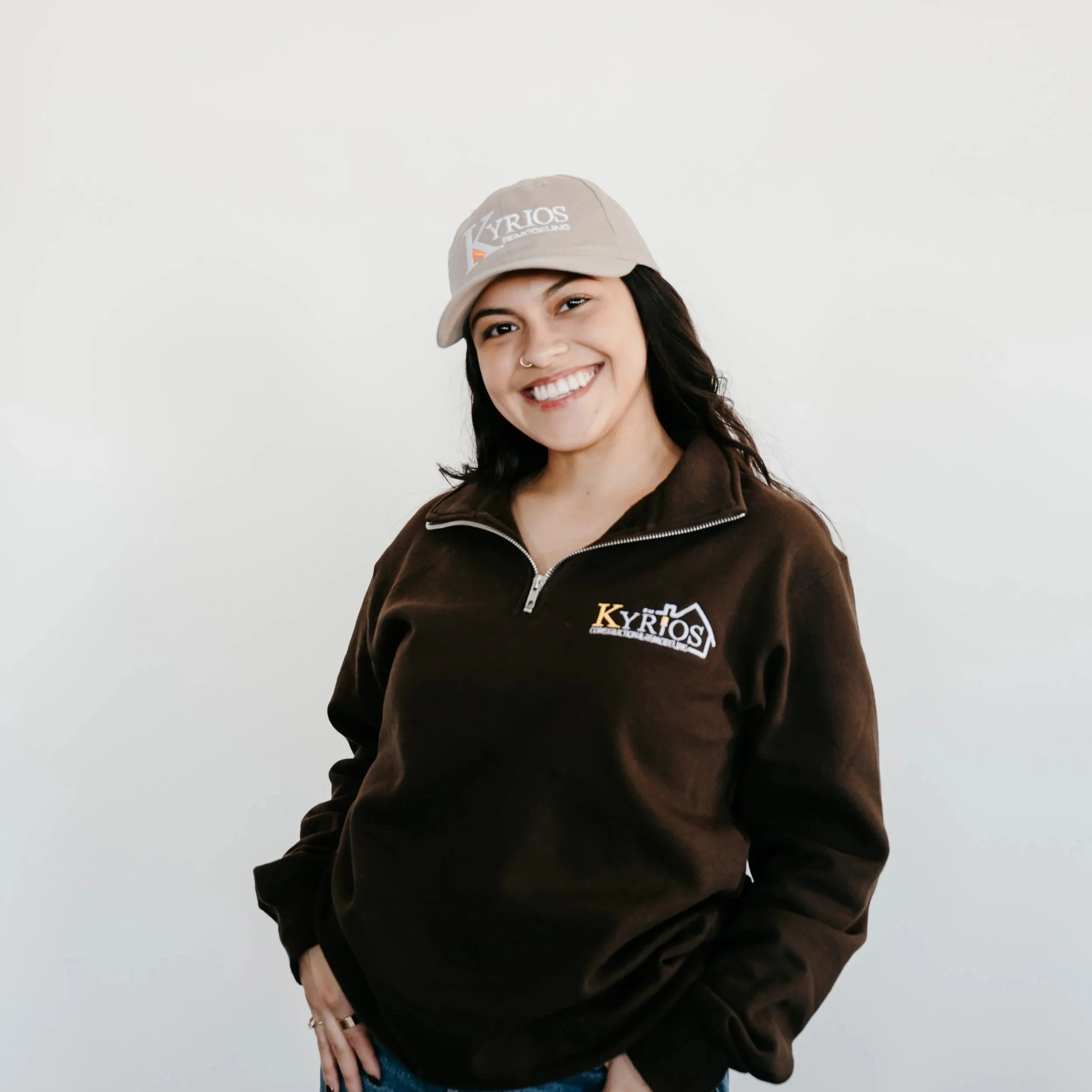 Smiling woman with dark hair wearing a black top against a plain background.