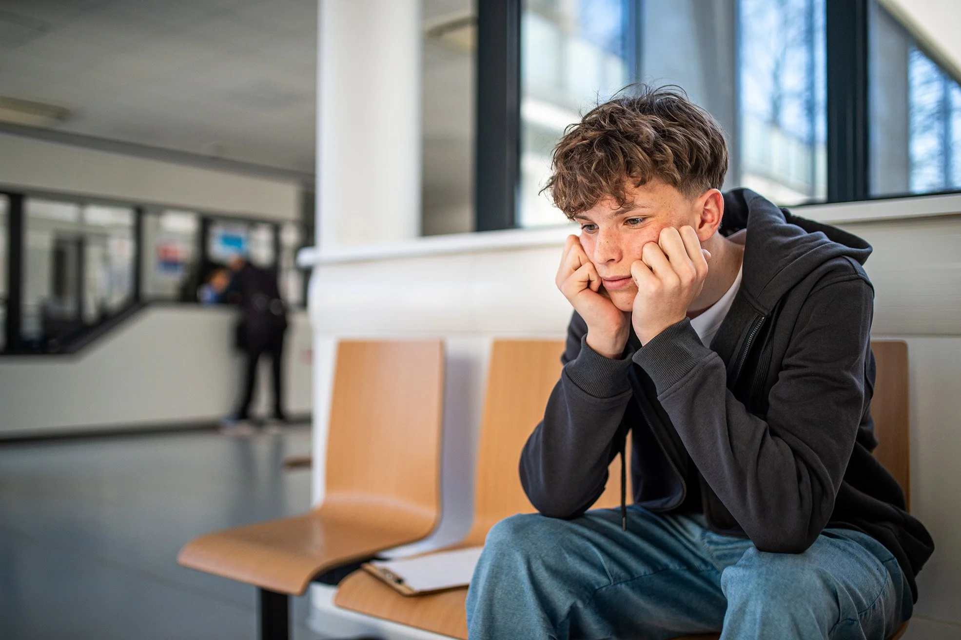 Anxious teenager waiting alone in waiting area