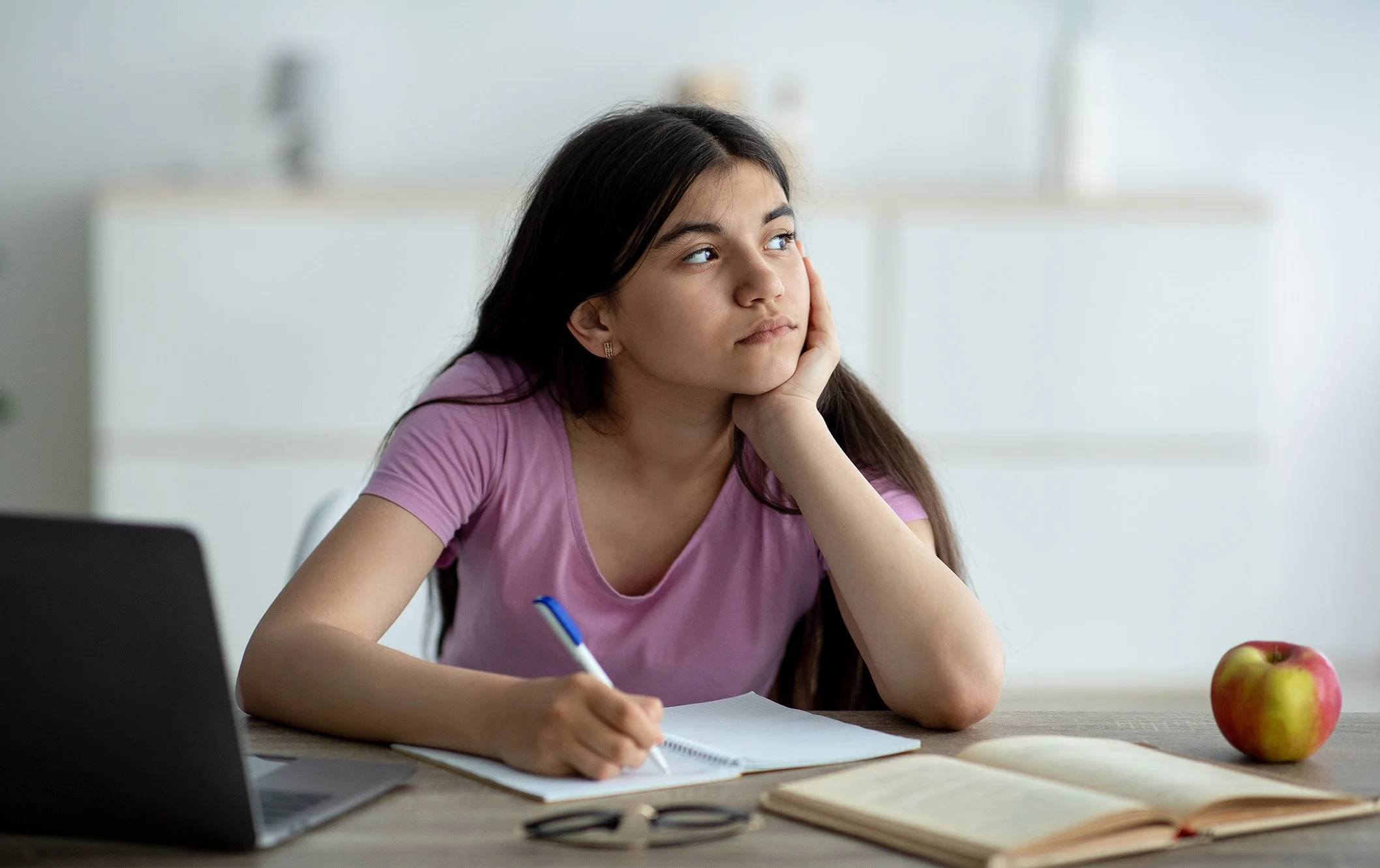 Thoughtful Indian teen girl with autism studying online