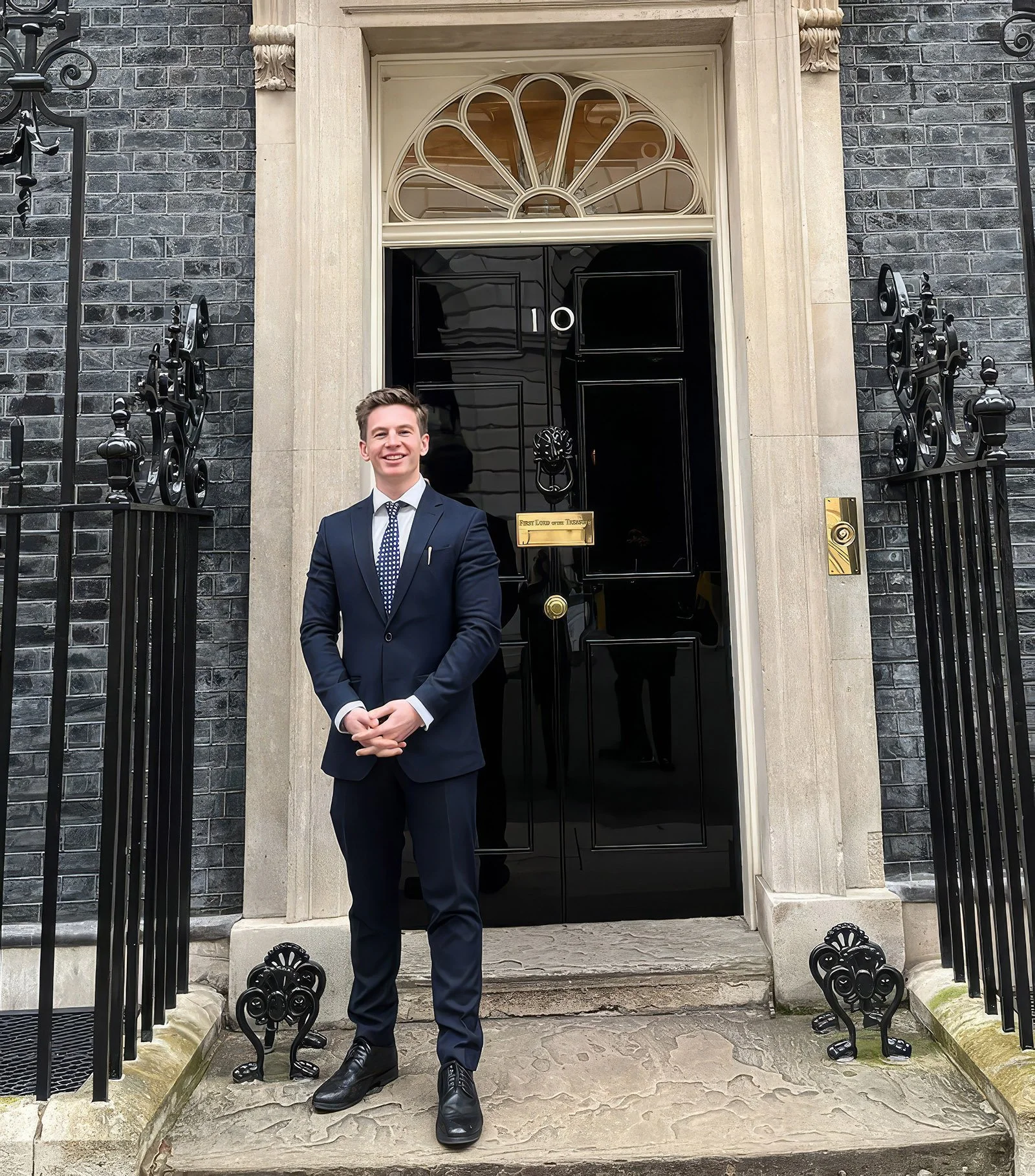 Dr Bradley Powell, Clincial Psychologist standing on the steps od 10 Downing Street