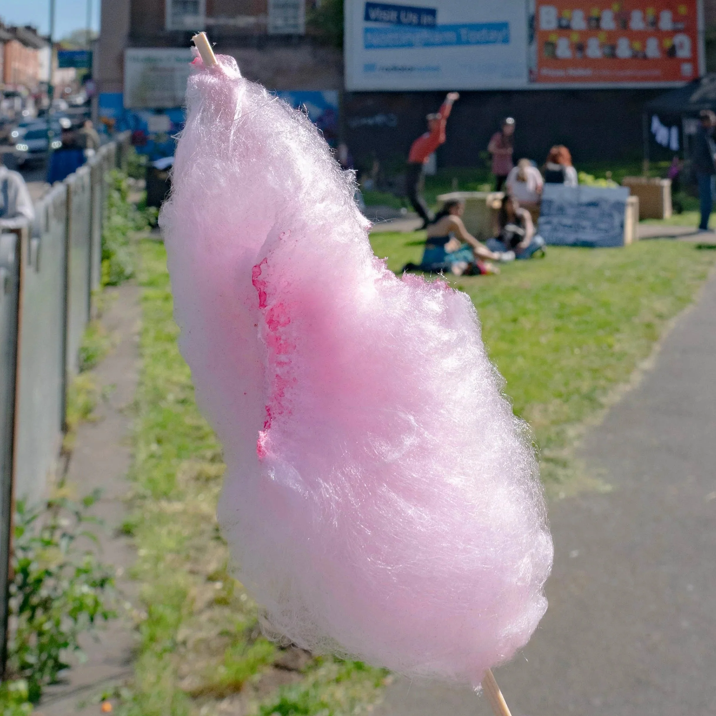 A hand holding pink candyfloss.