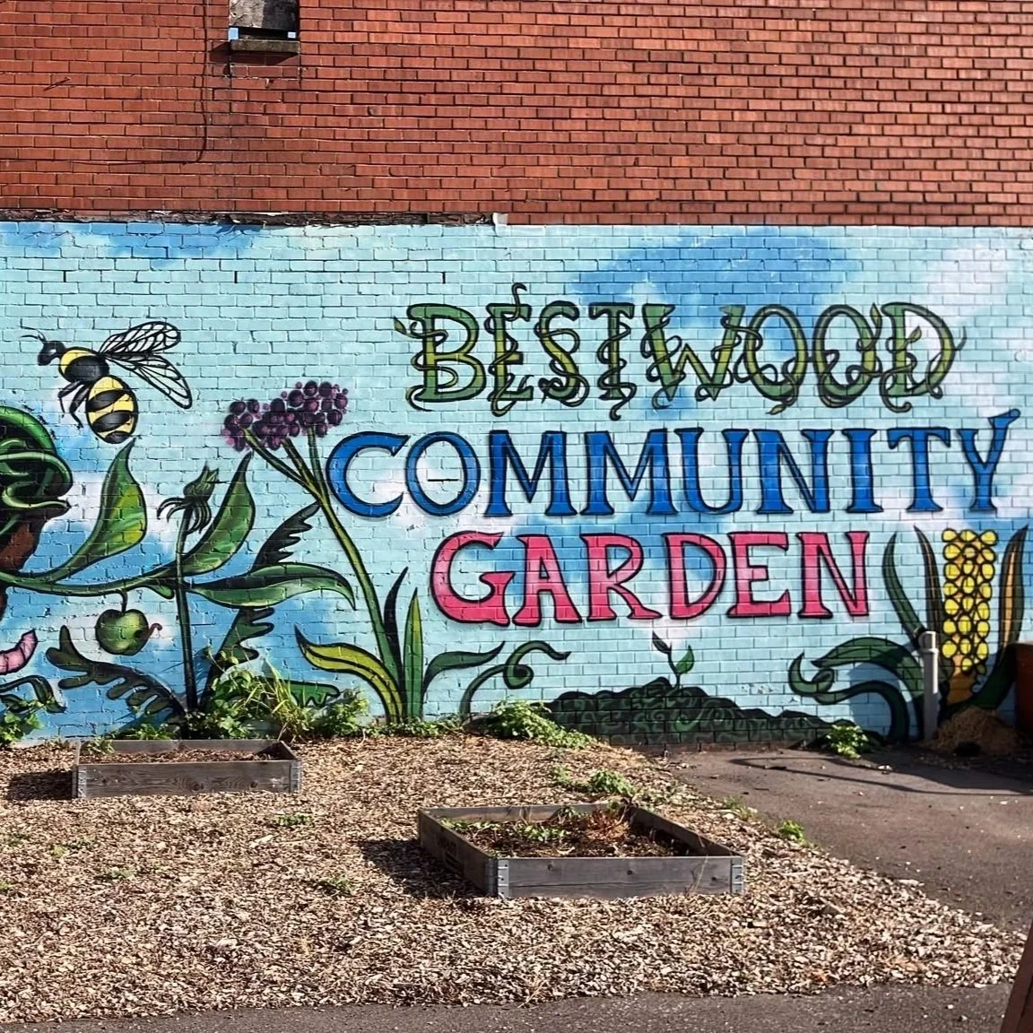 A series of photos featuring planters next to shops, flowers in the ground, a mural being painted, and people posing for the camera. 