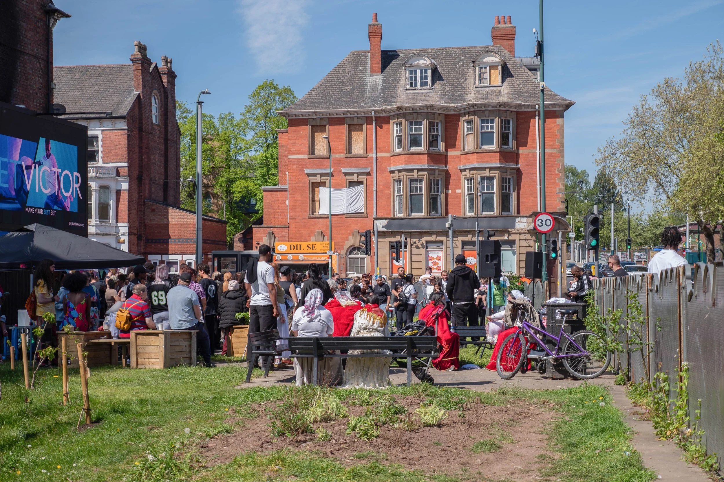 A festive gathering of people in the community garden. 
