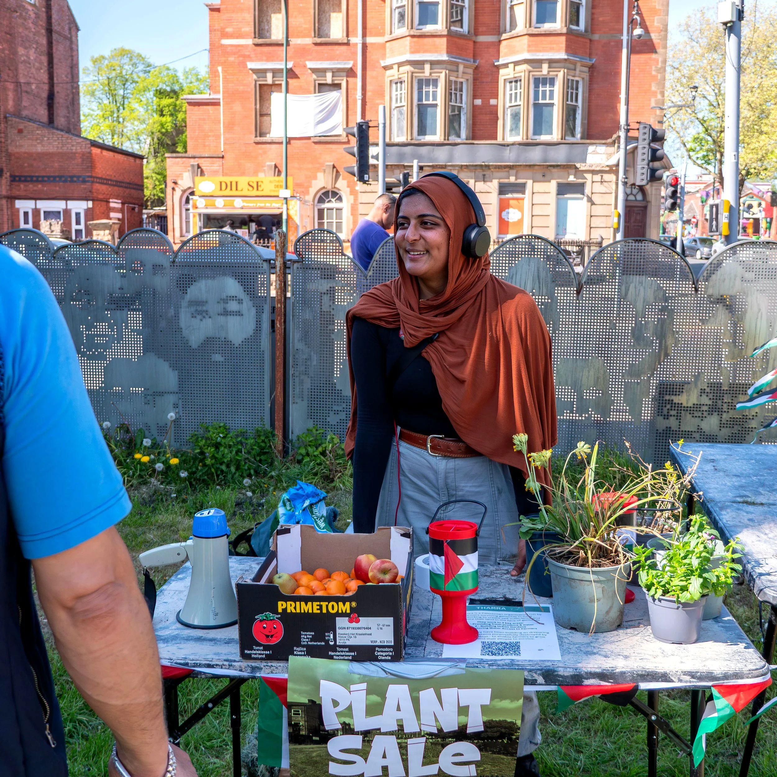 A person at the plant stall talking to customers. 