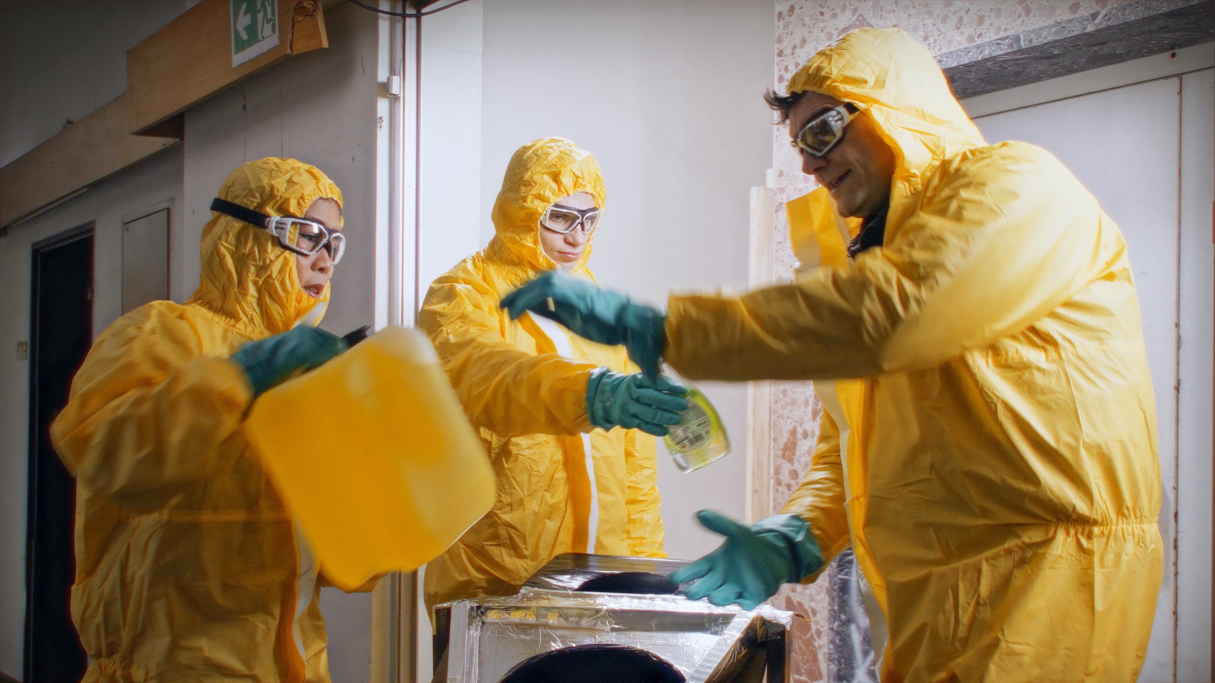 Mai, Lutz und Fabian in gelben Schutzanzügen