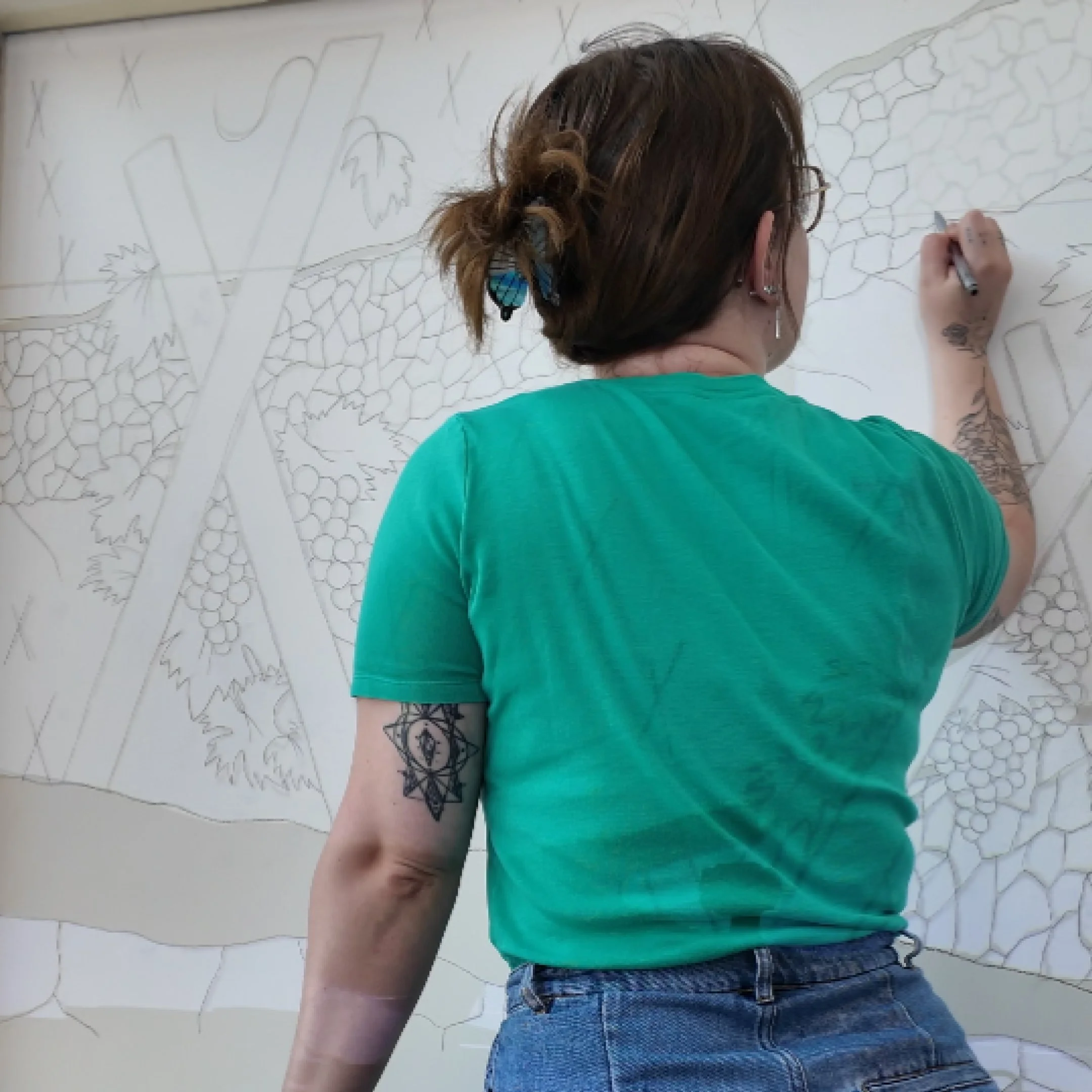 Amélie (Limygraph) qui crayonne la fresque sur le mur