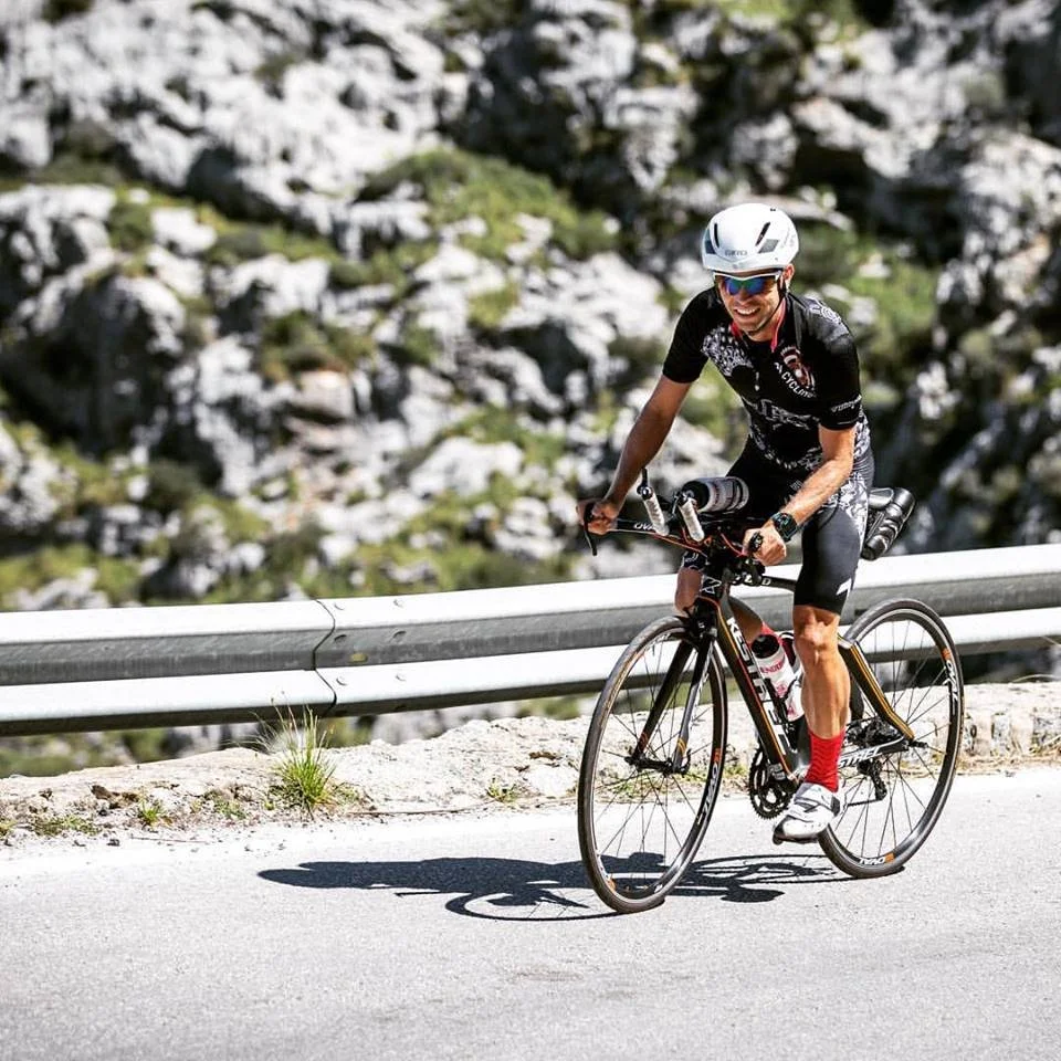 Athlete climbing up a hill on his bike