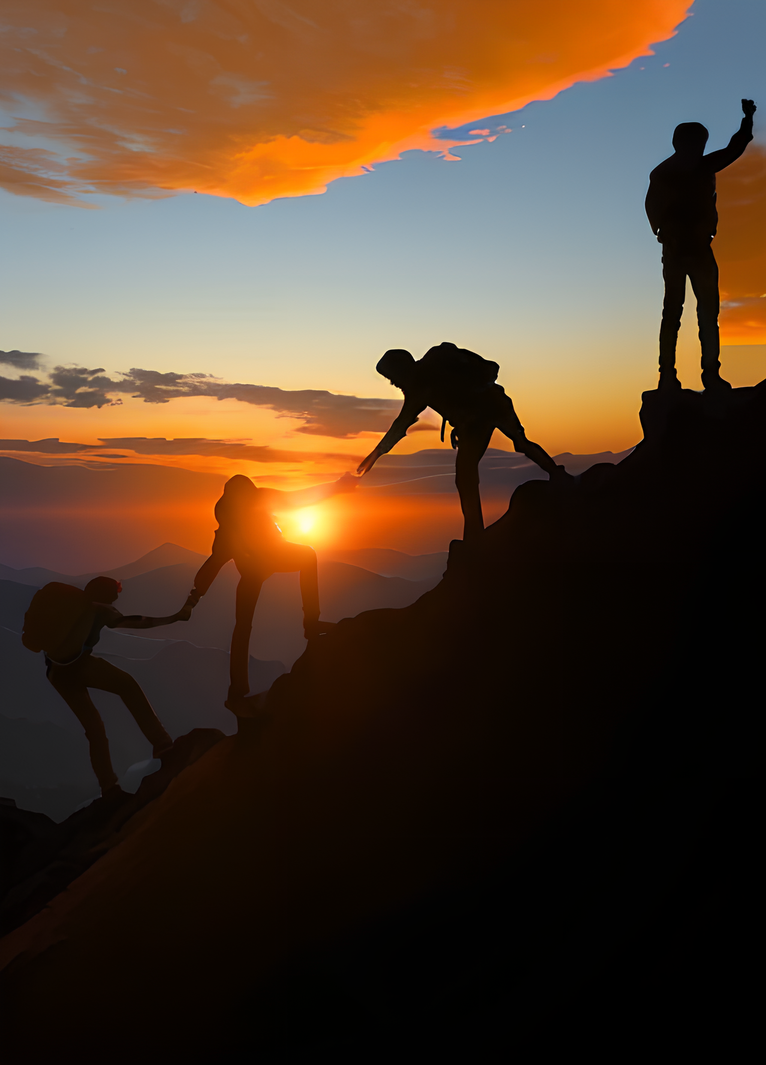 Silhouette of hikers climbing mountain at sunset
