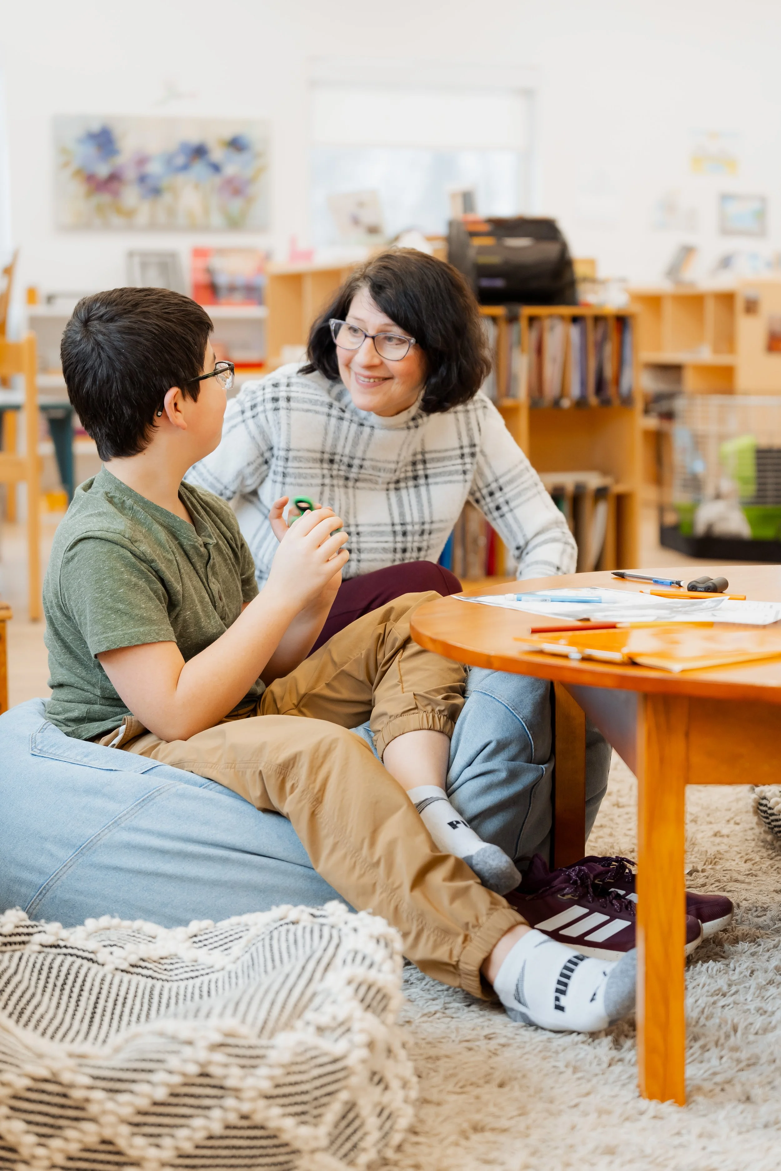 Elementary teacher talks with elementary student.