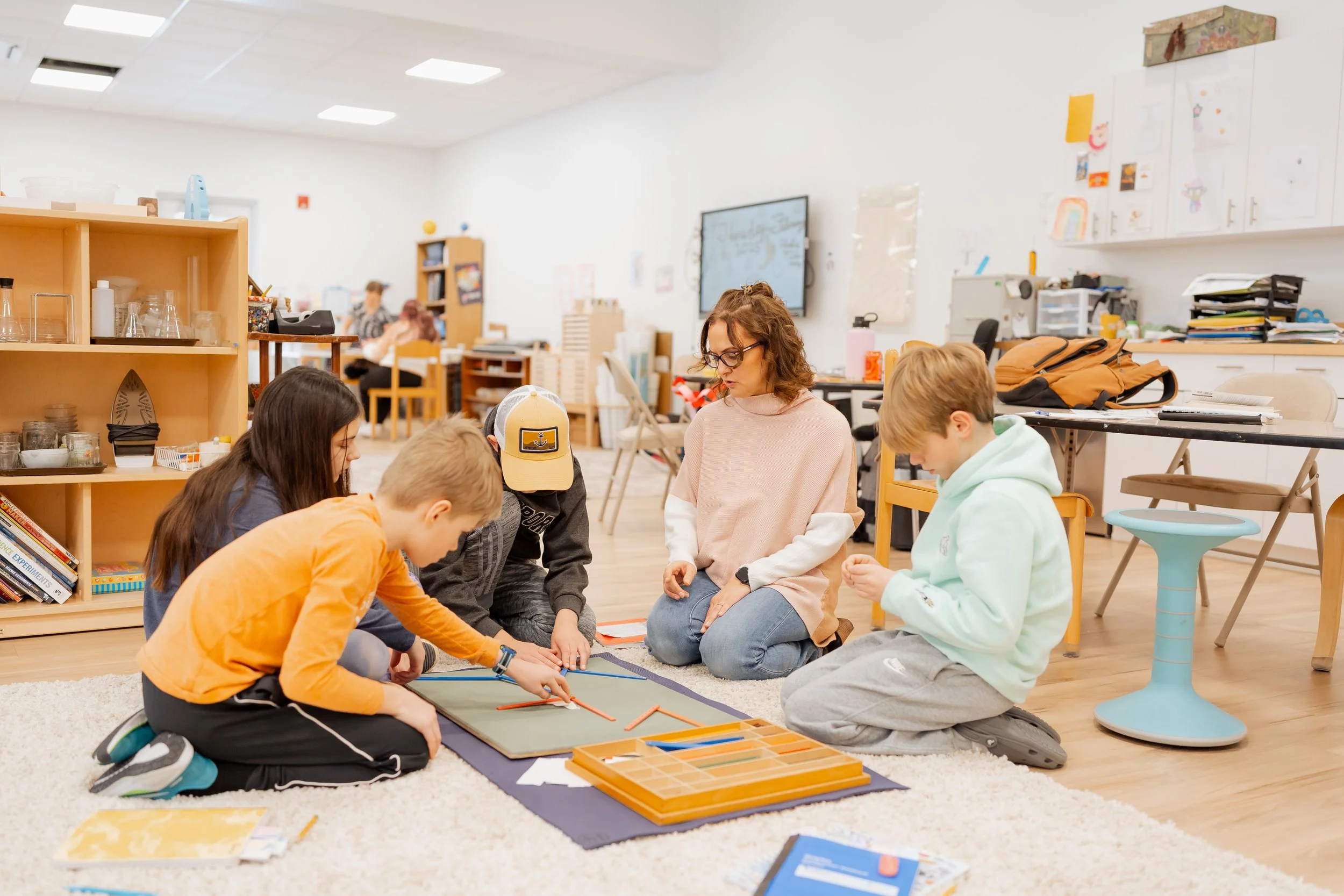 Elementary teacher works with group of elementary students.