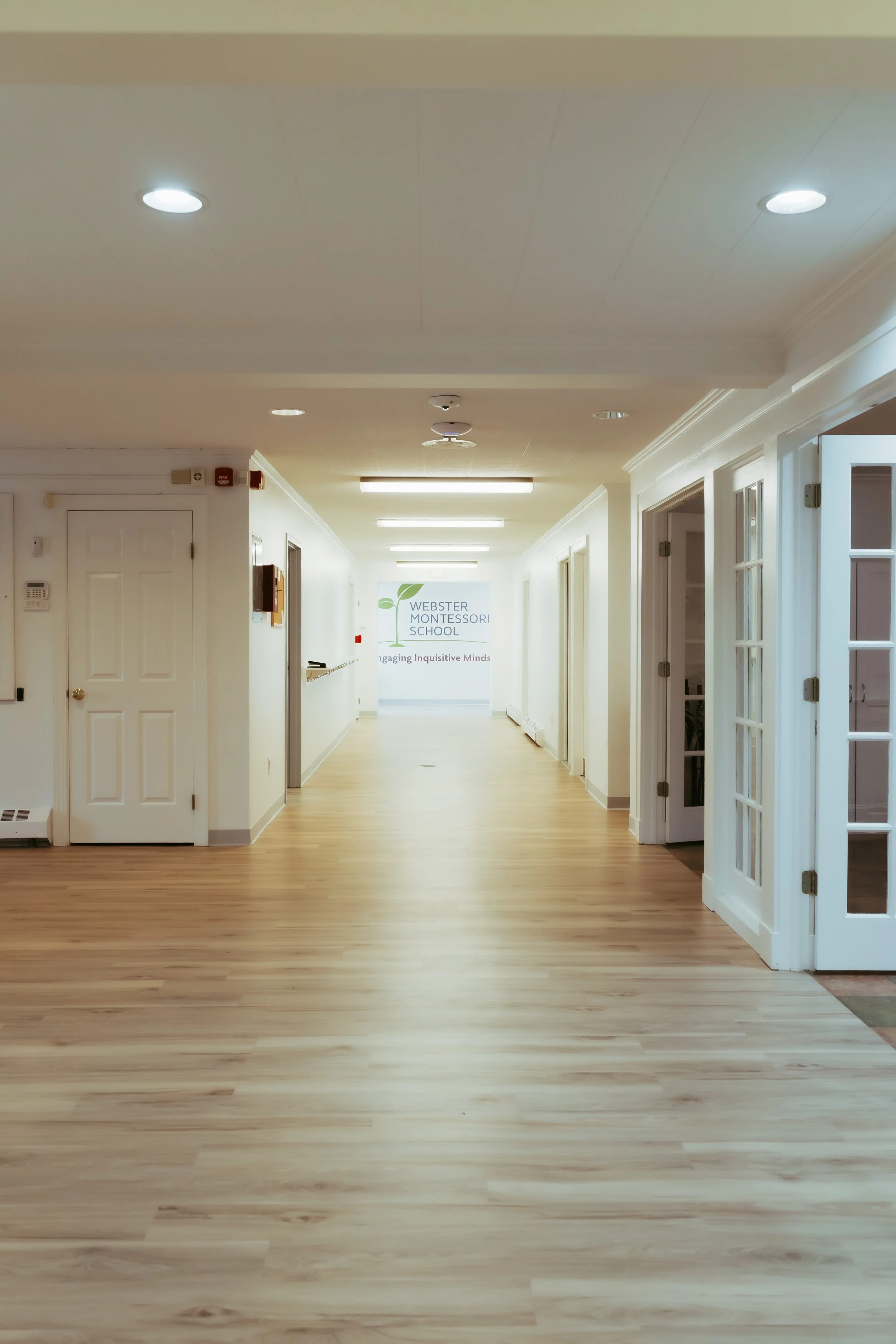 Inside of Webster Montessori School showing the school sign at the end of the hallway.