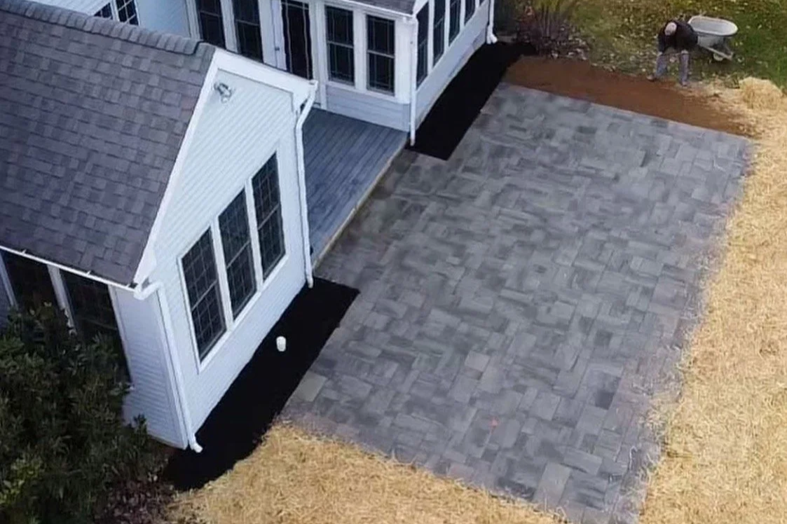 Custom Techo-Bloc shale gray stone patio with dark charcoal border installed by Meanix Landscaping in Chester Springs.
