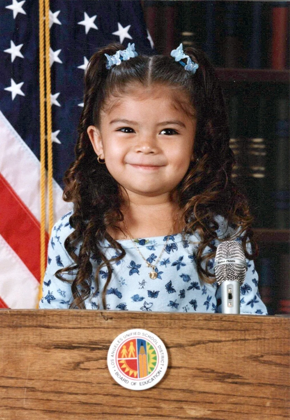 Sonia Yamilex Mata's Yearbook Photo. A girl with curly hair standing behind a podium with a Los Angeles Unified School District logo.