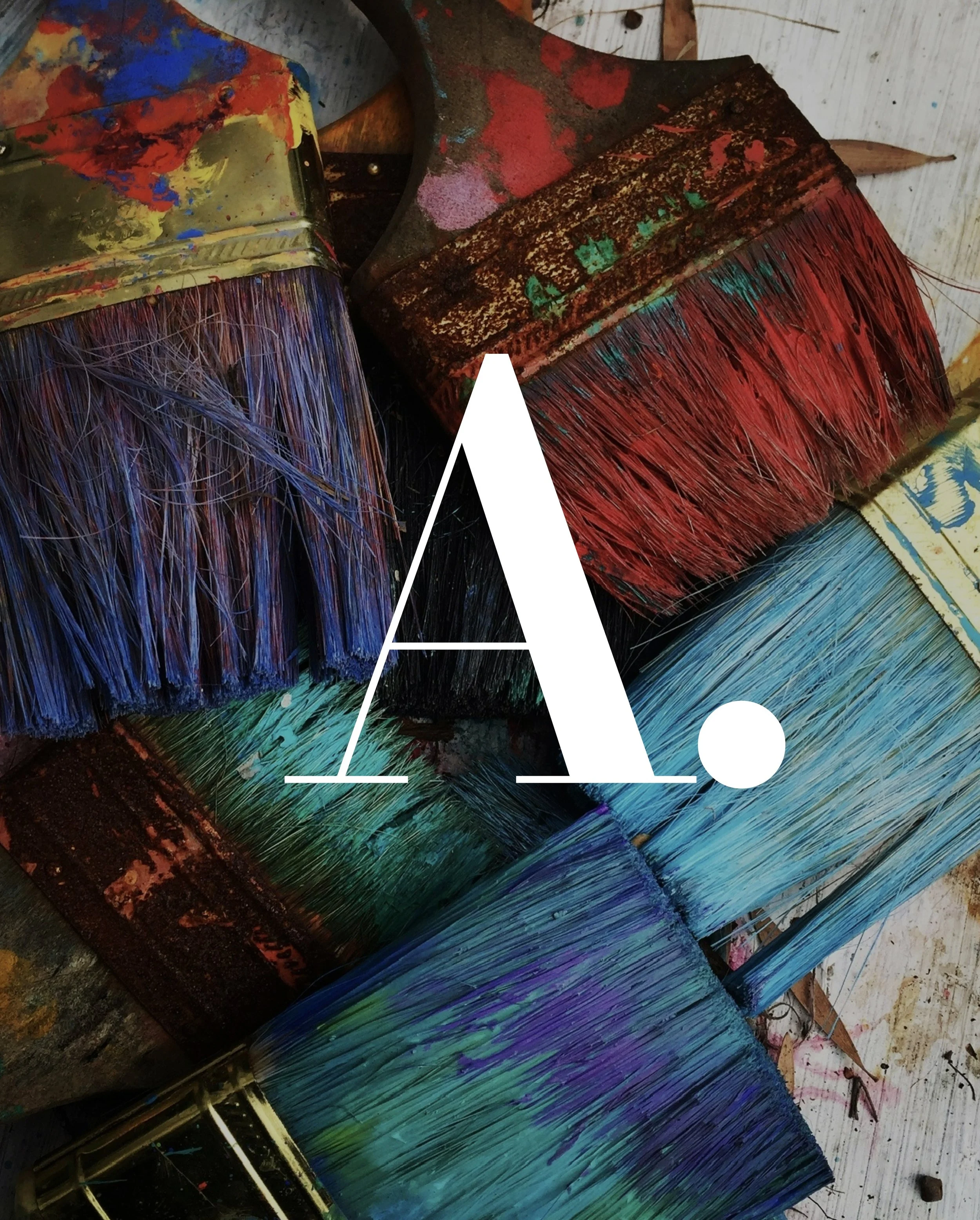 Paintbrushes with colorful bristles, displaying various colors of paint, broken paintbrushes, and a metal palette knife, all scattered on a surface.