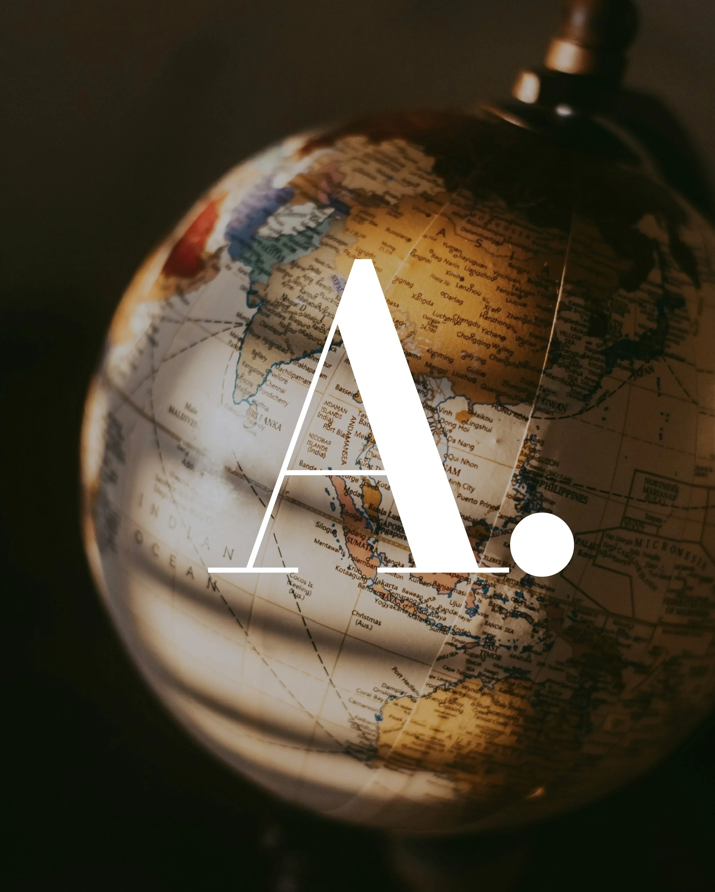 A globe featuring Asia and Australia with a large white letter 'A' and dot overlay.