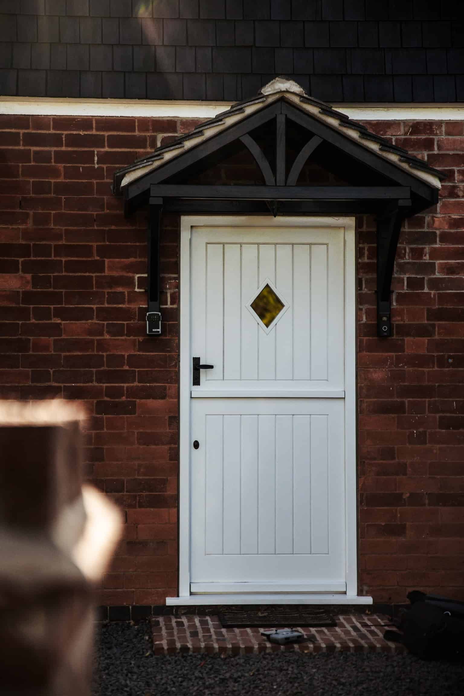 A diamond-shaped window on a wooden ceiling, showing a blurry outdoor scene with green foliage.