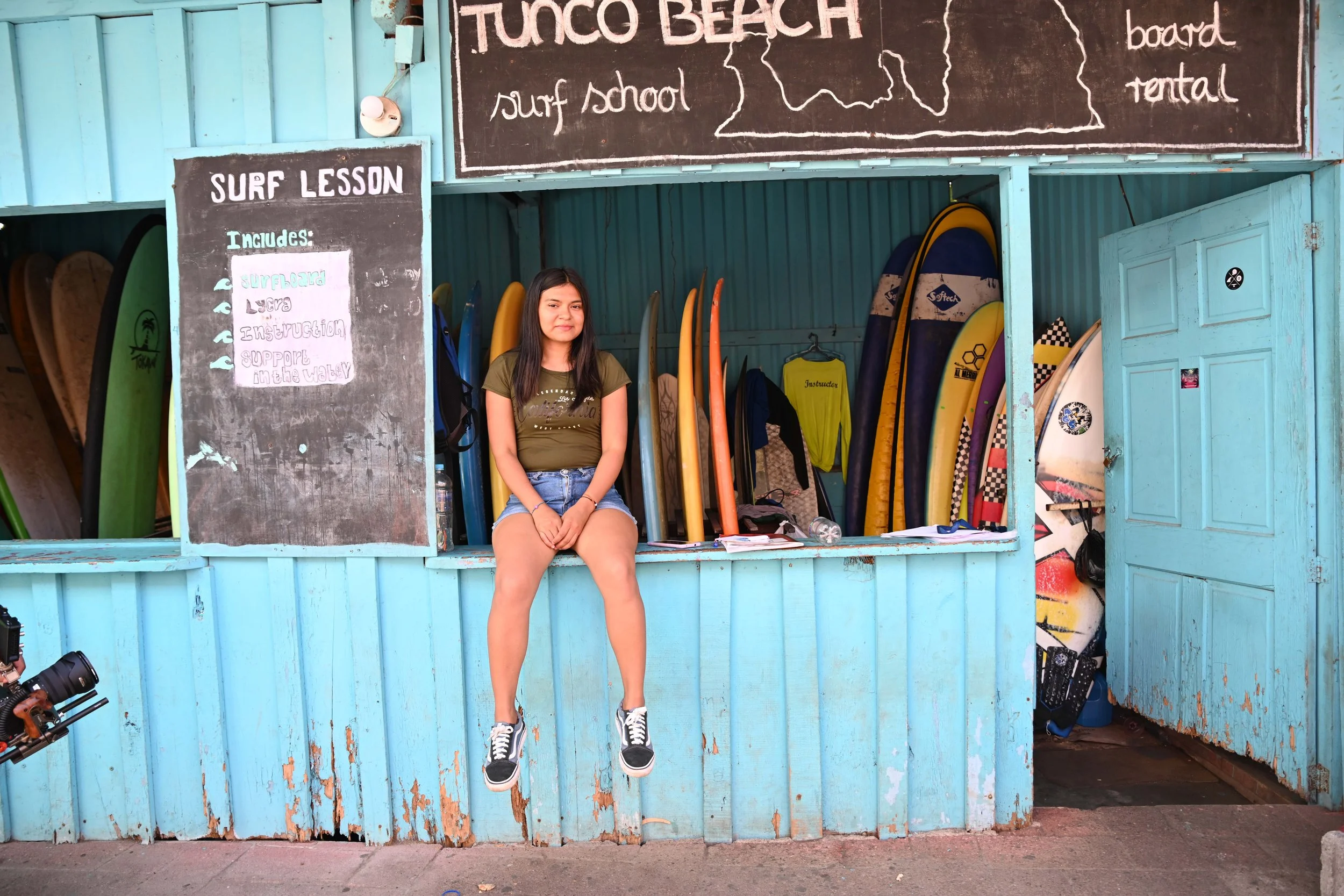 young girl sitting on surf shack