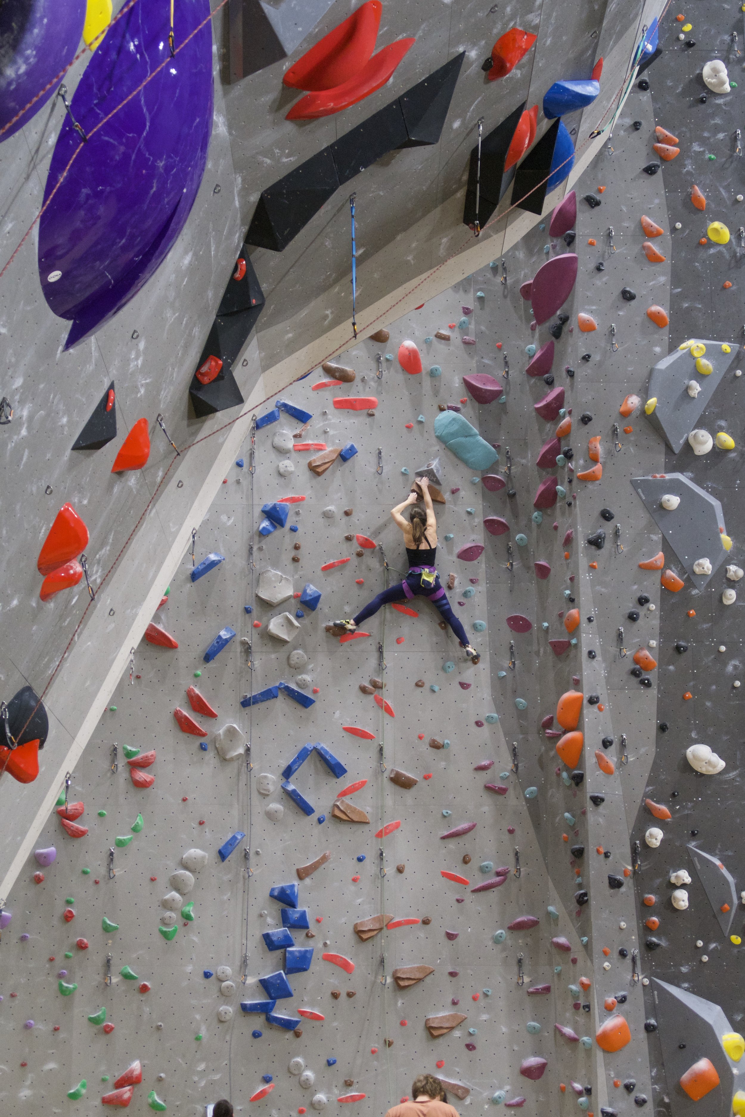 Frau klettert in der Halle
