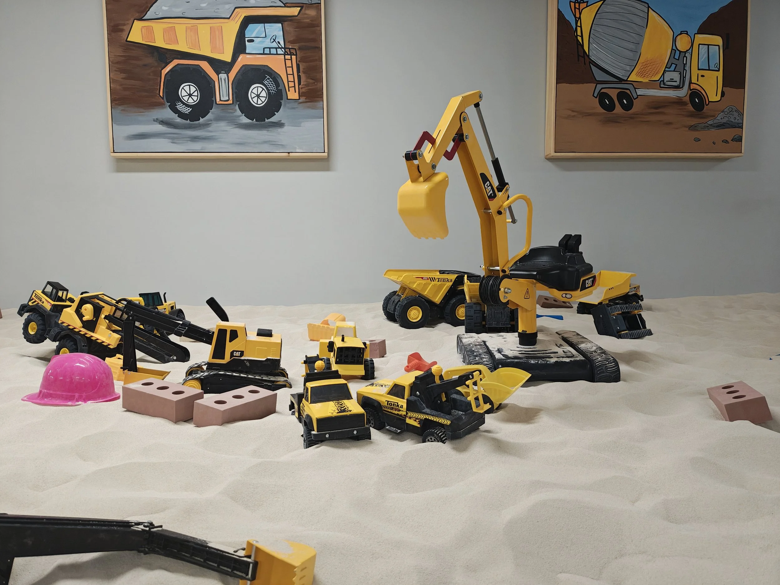 ride on excavator and other toys in sand