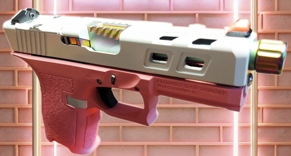 A colorful, custom-designed handgun with a rainbow-colored trigger and slide, displayed on a stand against a pink brick background.