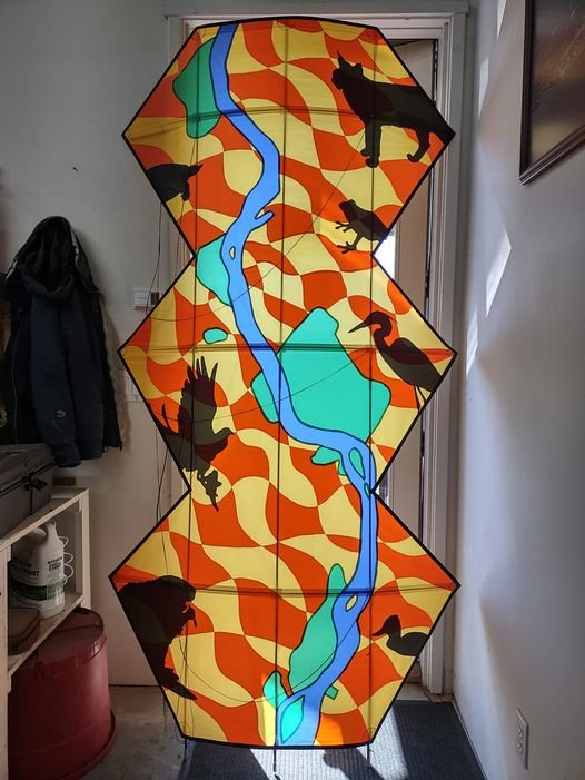 Chris Hanson Bellingham, Wa.
Combining strong colors, unusual animal and bird graphics and a tall shape that features the Yellowstone River, Chris created a striking 8’ appliquéd kite that held its own in the Oregon sky. Chris lives in a beaut