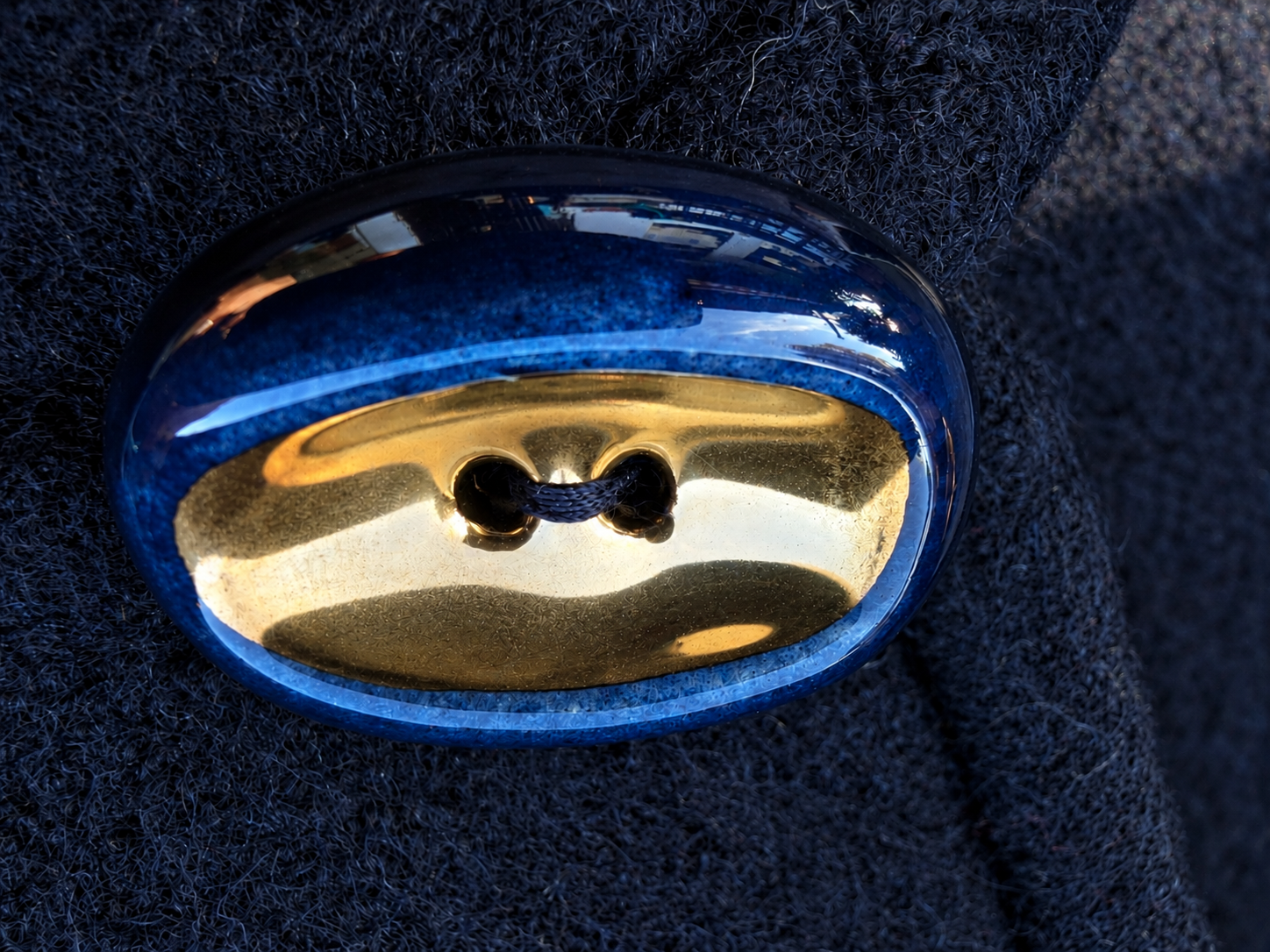 Glossy Blue and Gold Button on Wool.png