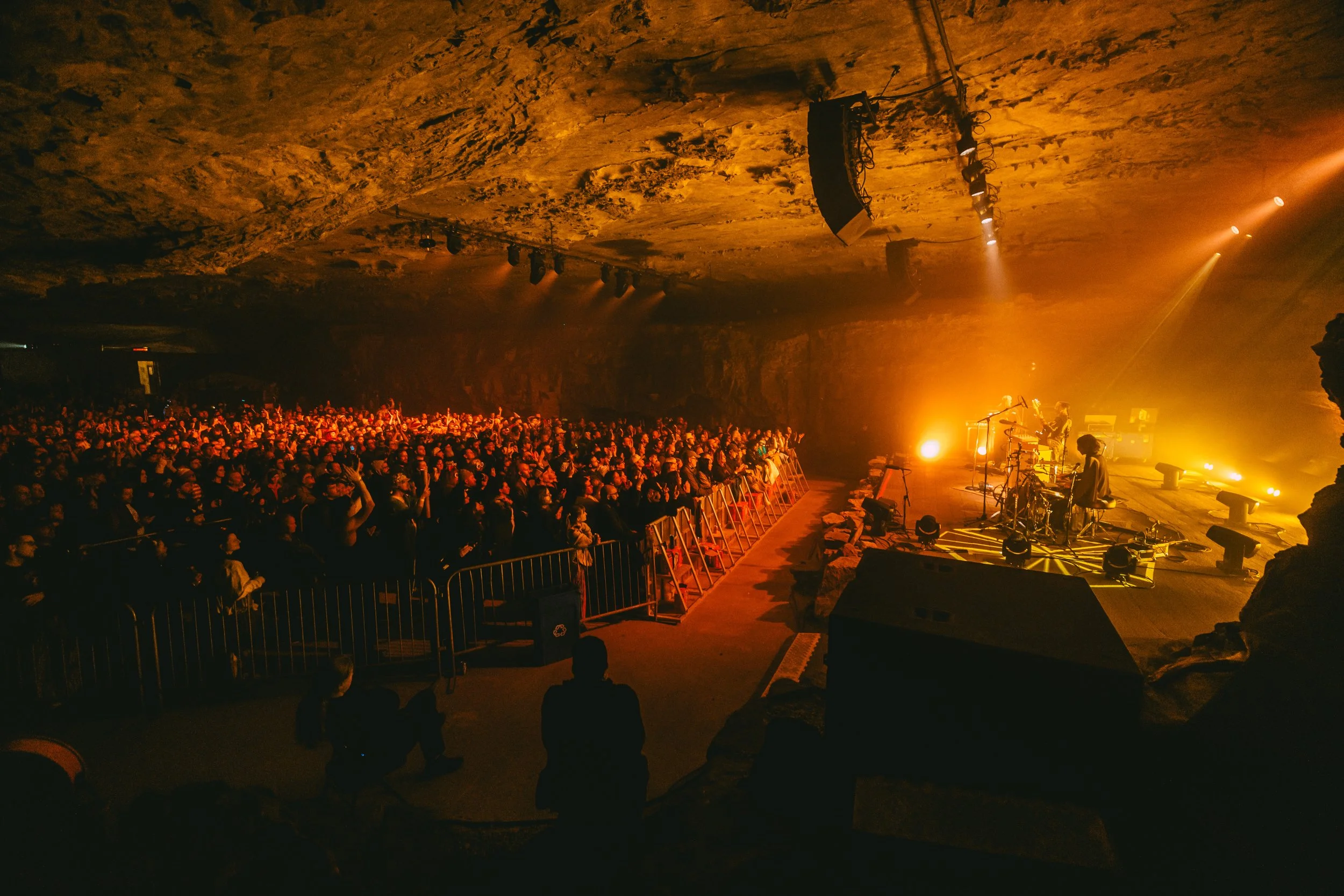 An underground concert with a large crowd watching a band perform on stage at The Caverns in Pelham, TN.