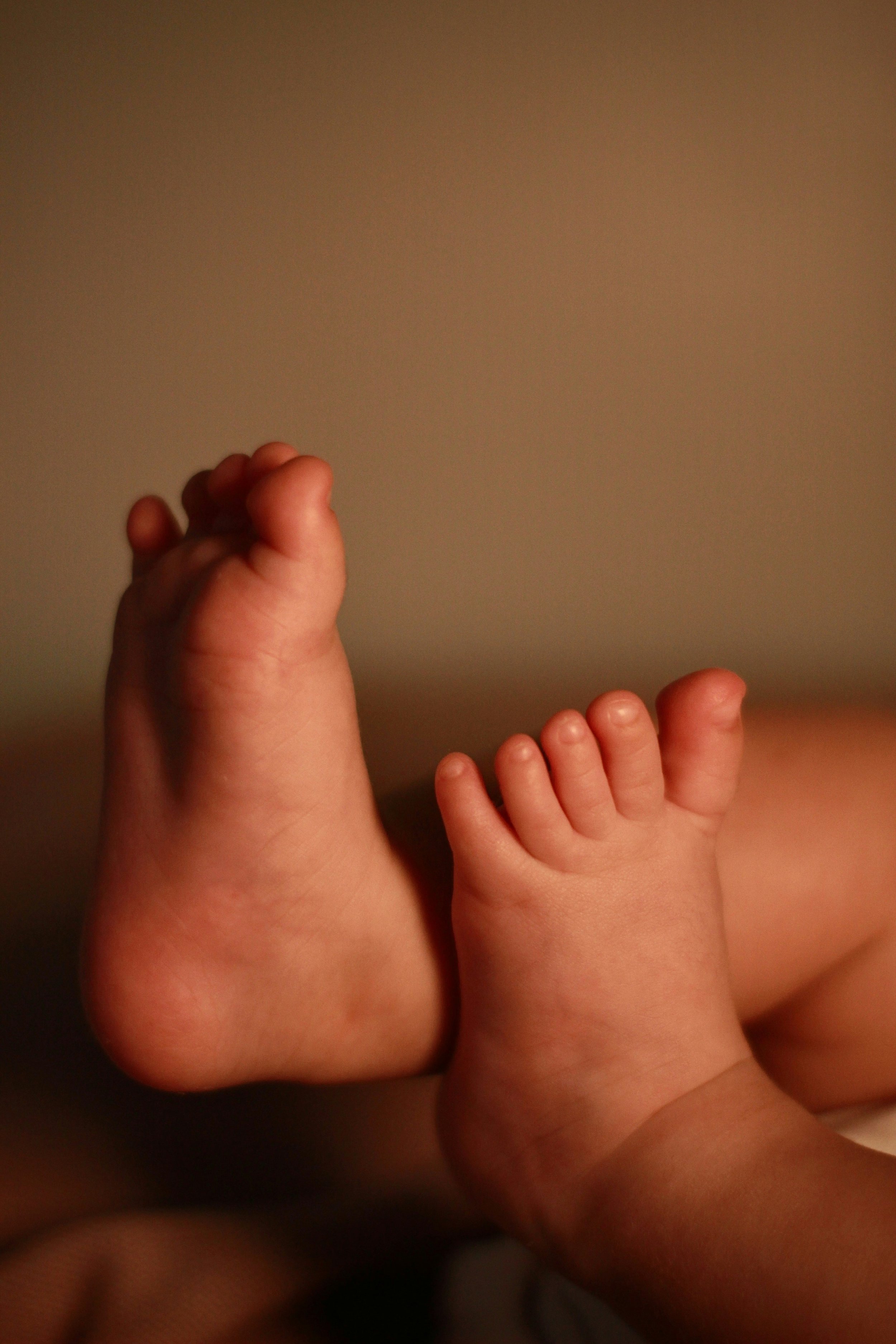 Close-up of a baby's feet against a neutral background.