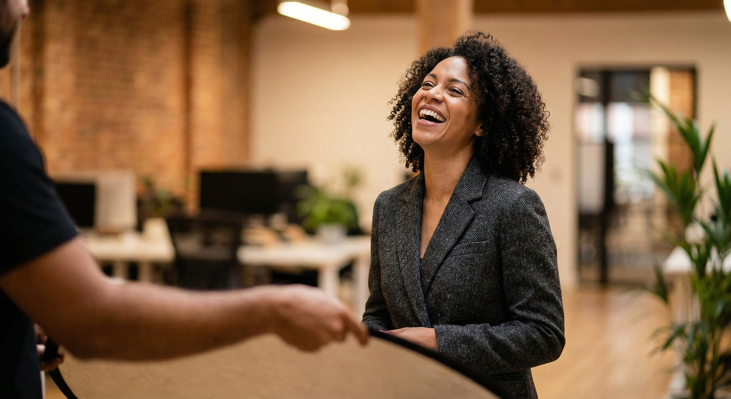 A candid, authentic corporate portrait of a woman laughing, showcasing the "approachable authority" trend for 2026 business photography.