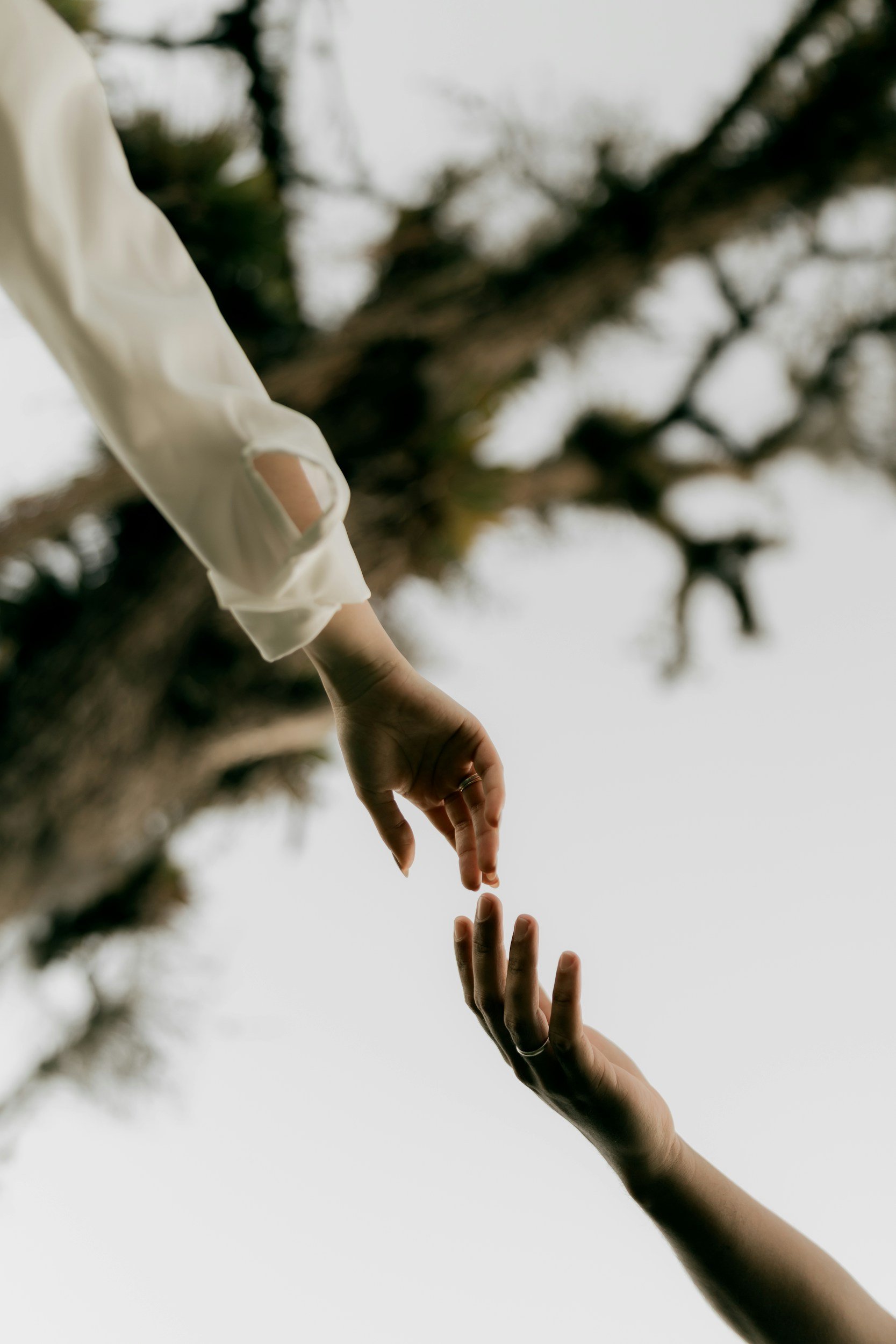 Two people reaching towards each other, representing meaningful human connection
