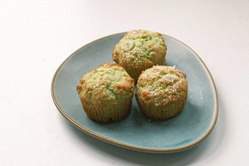 Top view of pistachio muffins on a green plate