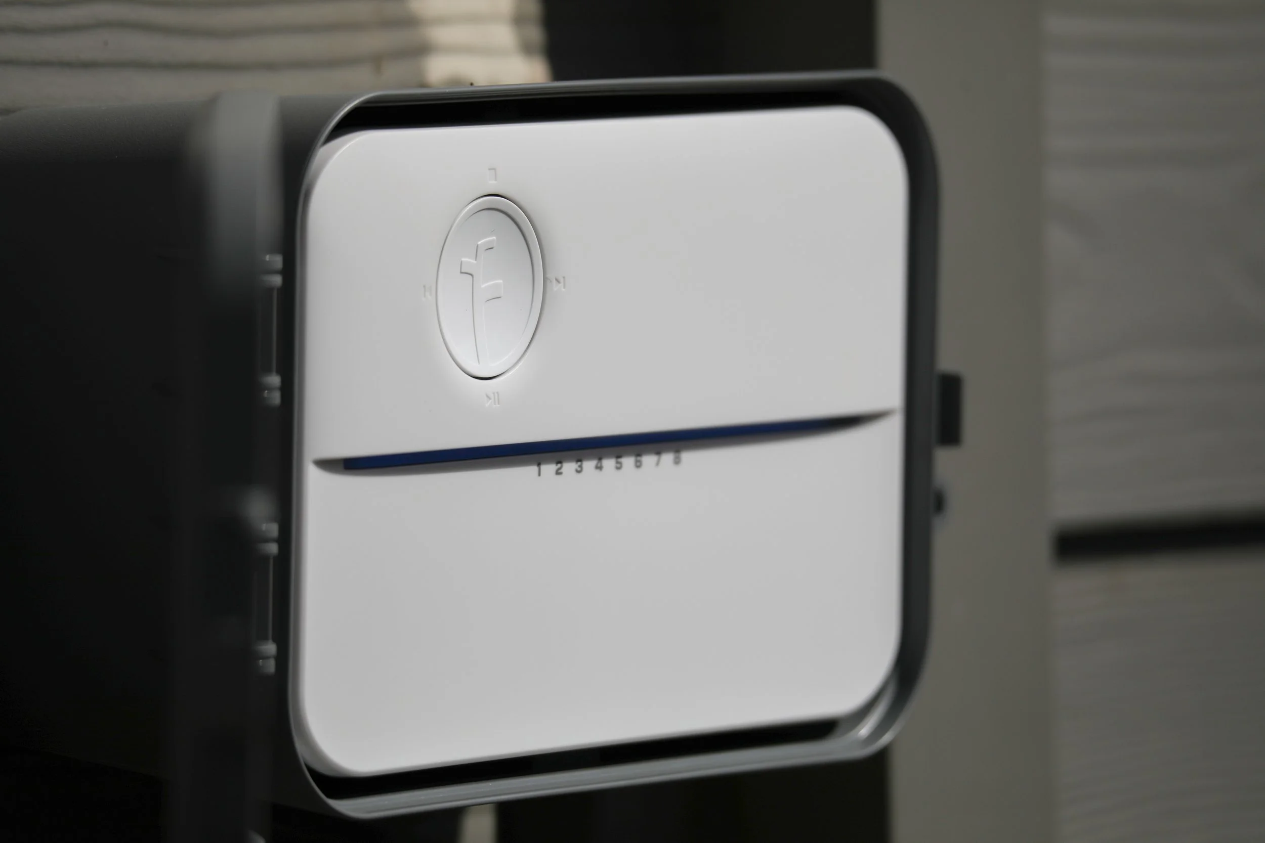 the rachio 3 installed on the outside of a home.