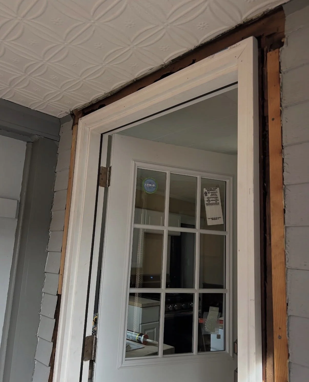 Exterior door frame repair located in mudroom in progress, showing structural adjustments and trim work during a door replacement project by P Jordan Construction in New Hampshire