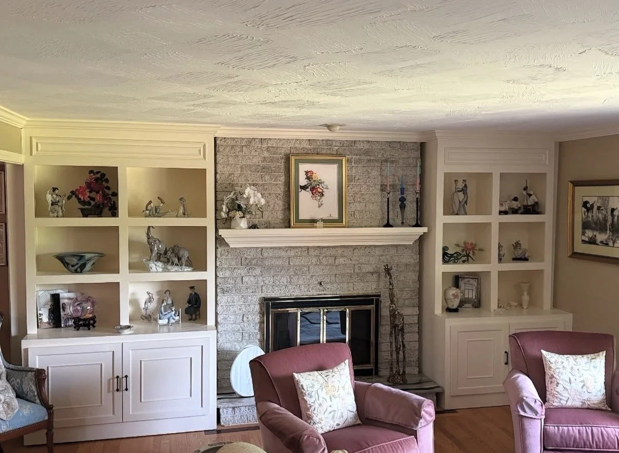 Custom built-in cabinets and shelving installed on both sides of brick fireplace wall in a living room by P Jordan Construction in New Hampshire