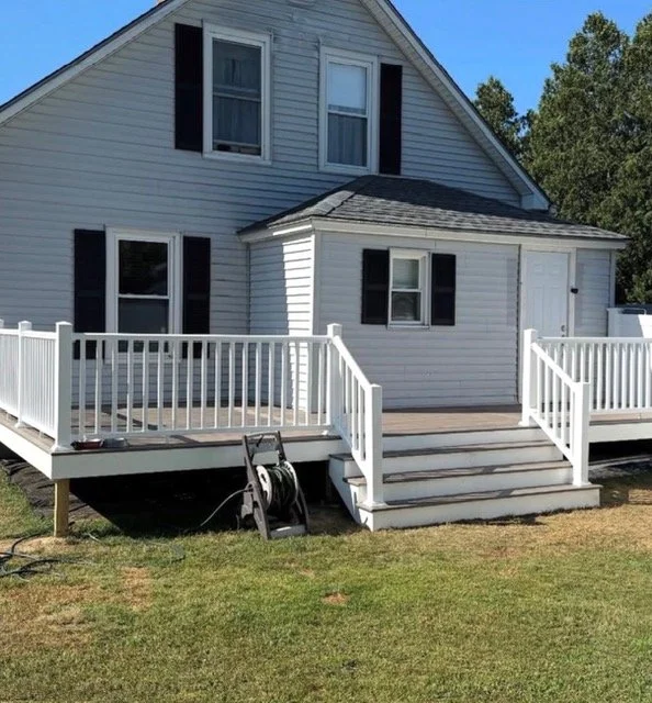 Newly built residential decks with white railings and stairs installed on a single-family home by P Jordan Construction in New Hampshire