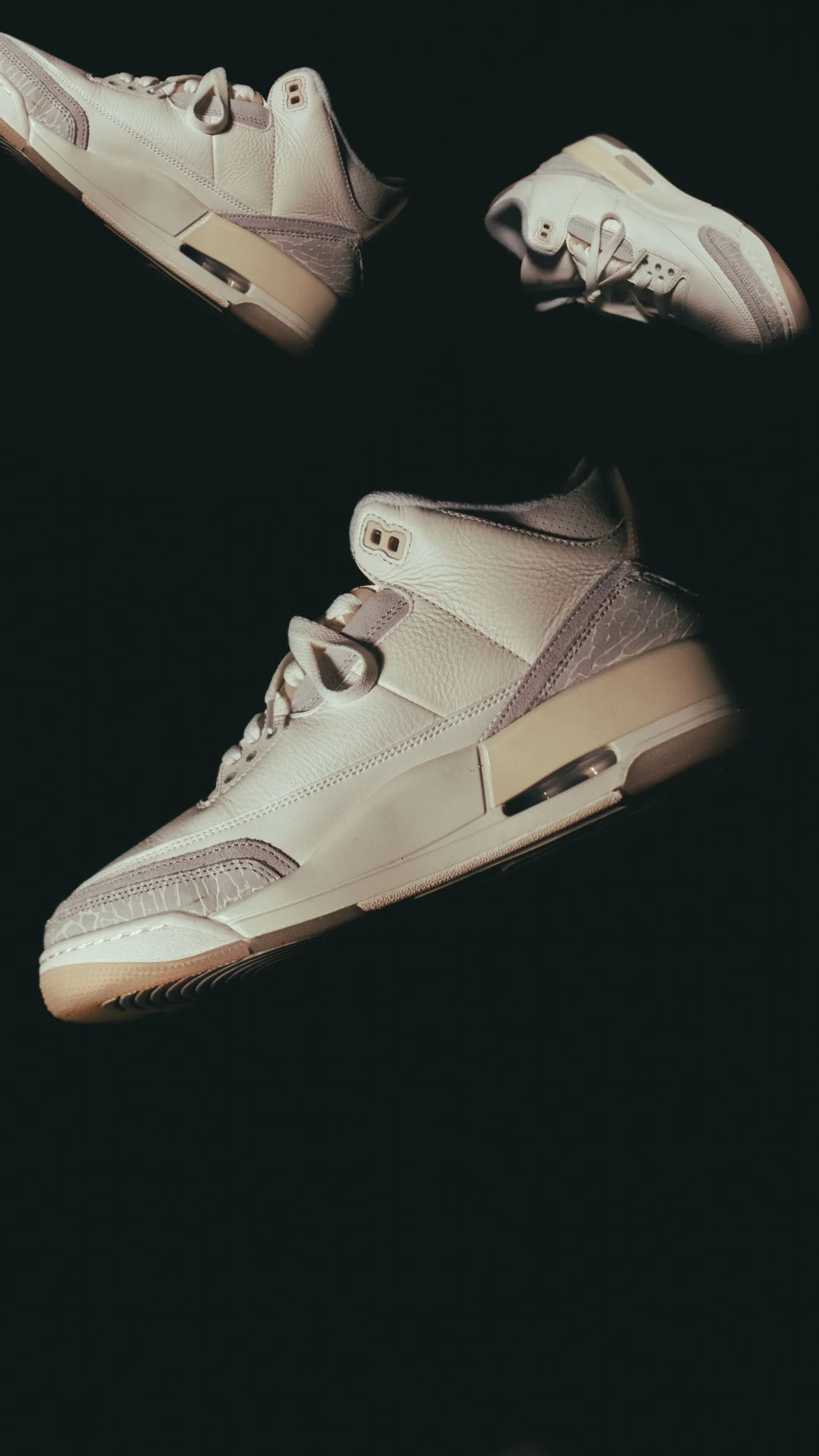 White sneakers with gray accents on a black background.