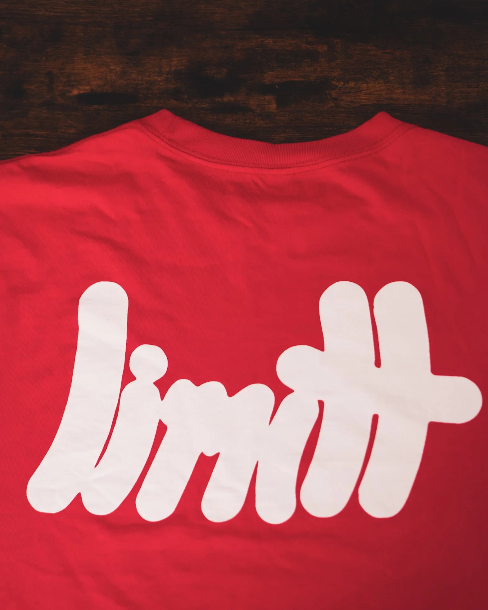 Red shirt with "limit" printed in white letters.