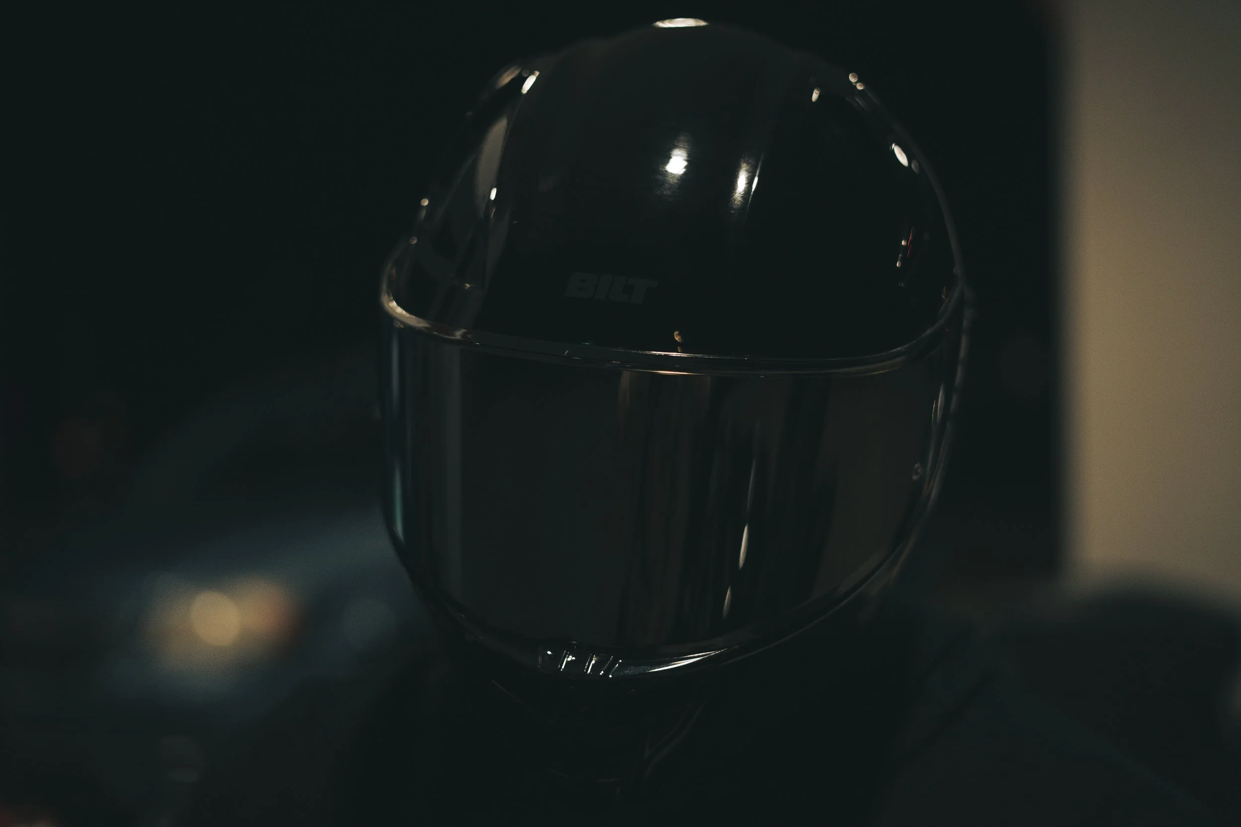 Close-up of a person wearing a black motorcycle helmet with a tinted visor.