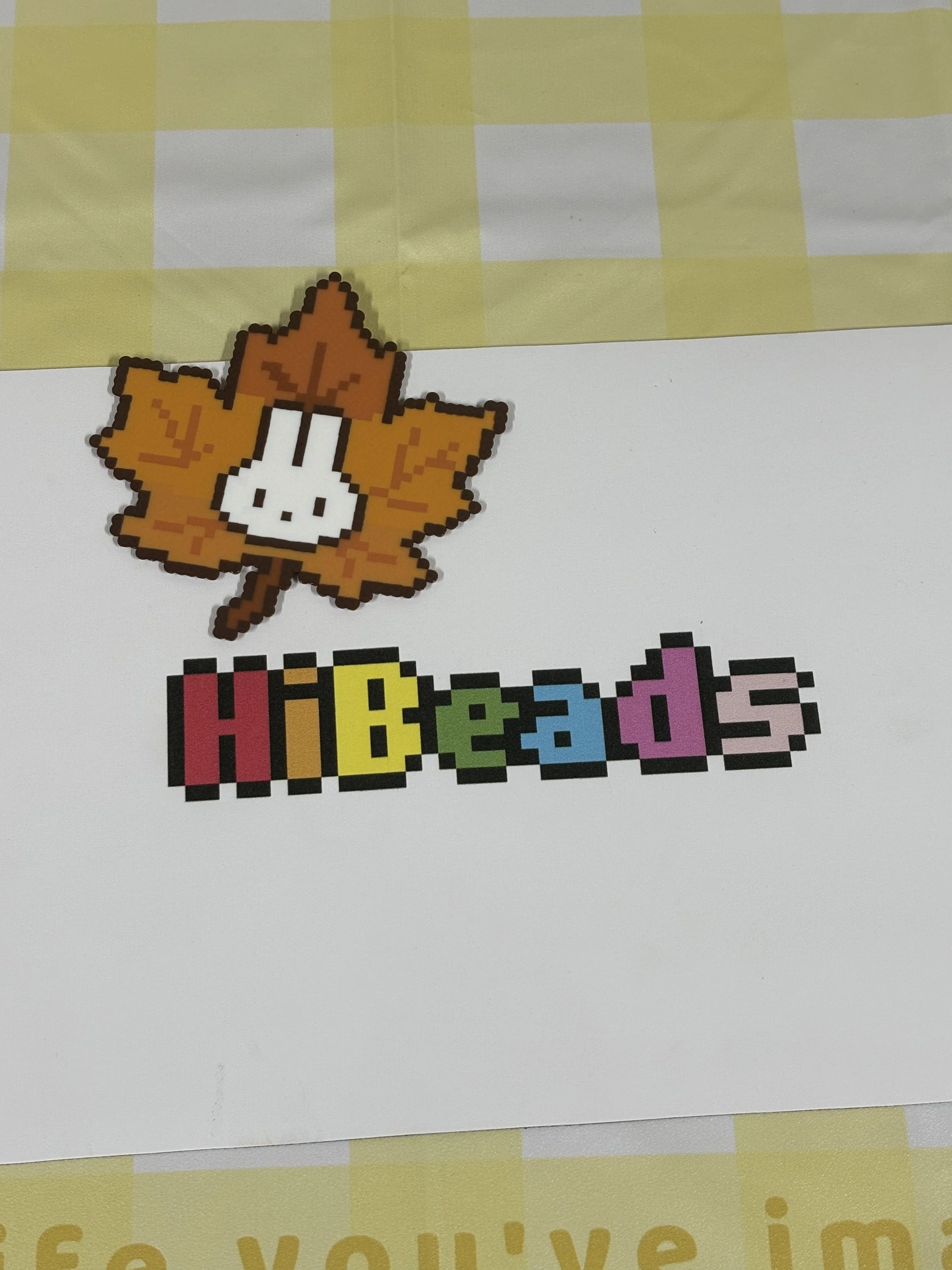 Pixel art style leaf with a mushroom and the colorful word 'Hibeads' underneath.