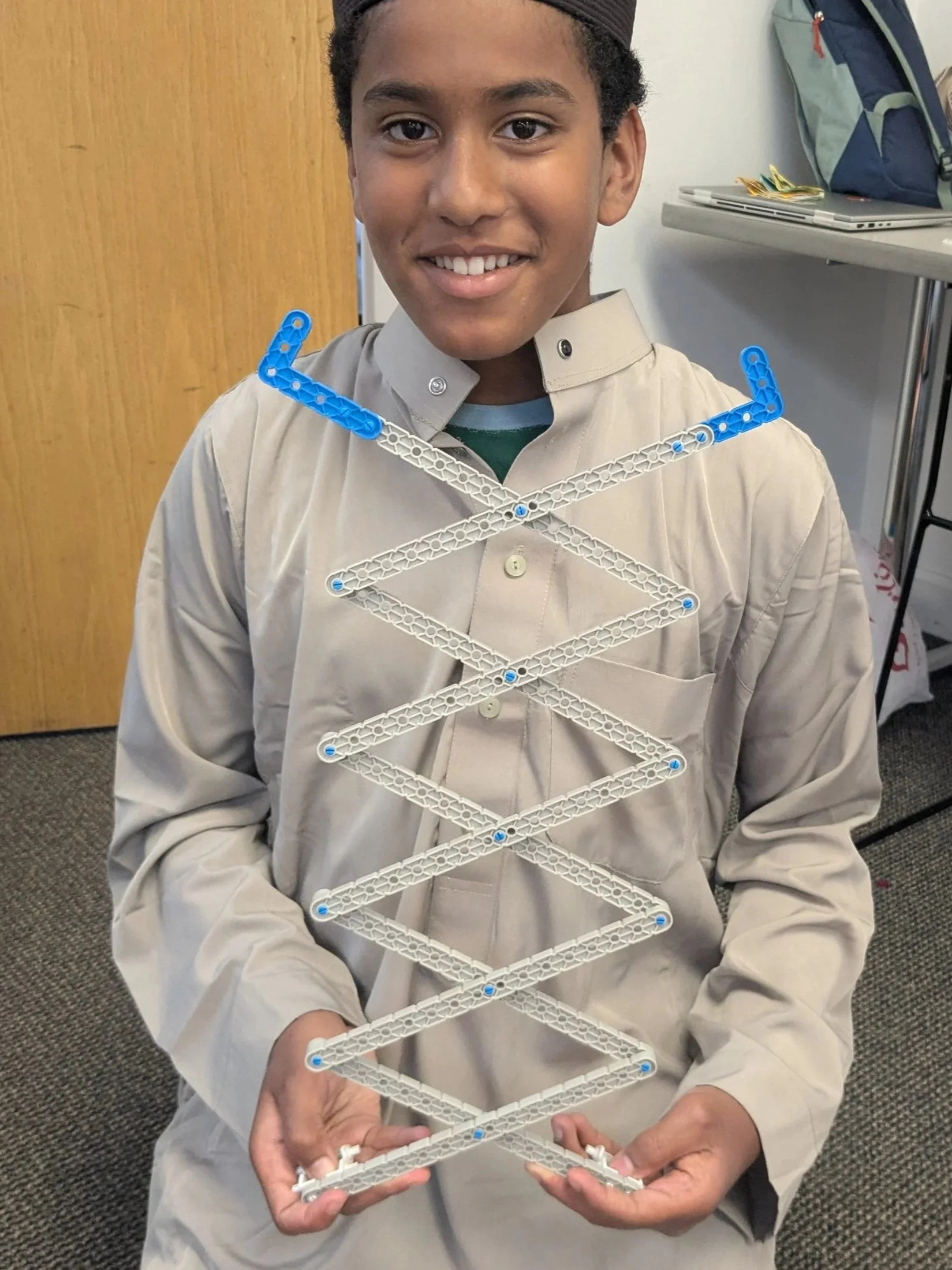 Student holding a scissor linkage they built during a Brain Busters engineering class