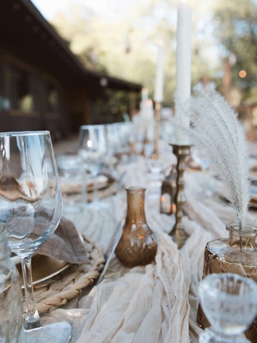 Outdoor wedding table decor with white linens and floral arrangements