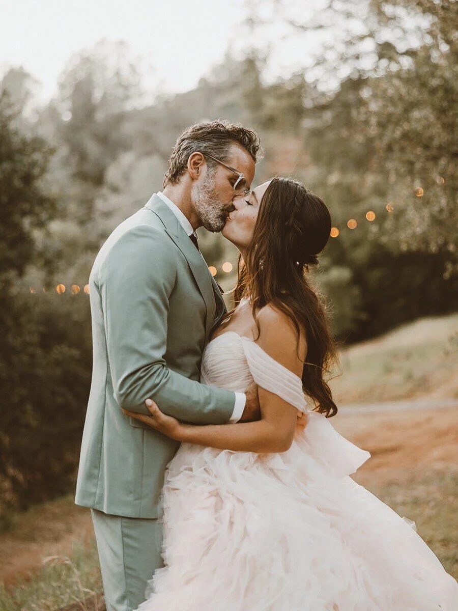 Bride and groom embracing in picturesque Sierra Nevada foothills landscape at Deloro Valley