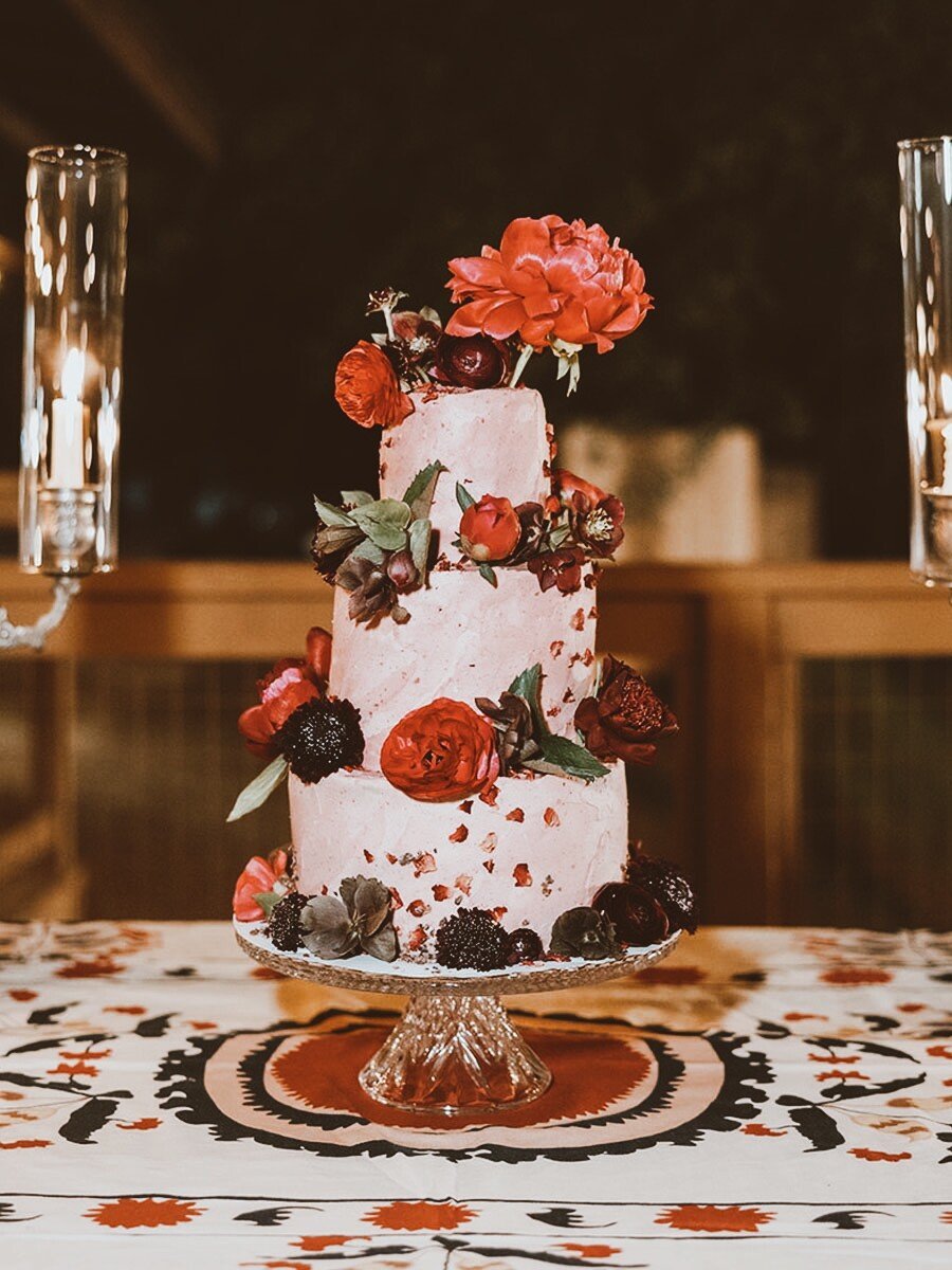 Beautiful wedding cake with floral decorations centered on table
