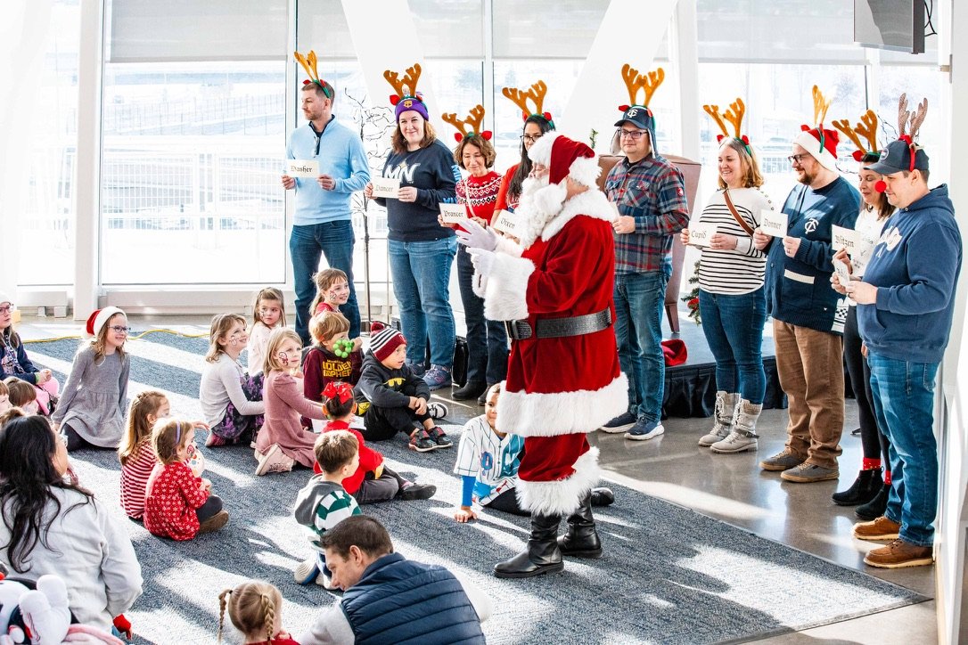 Santa Claus reading to children during a holiday event.