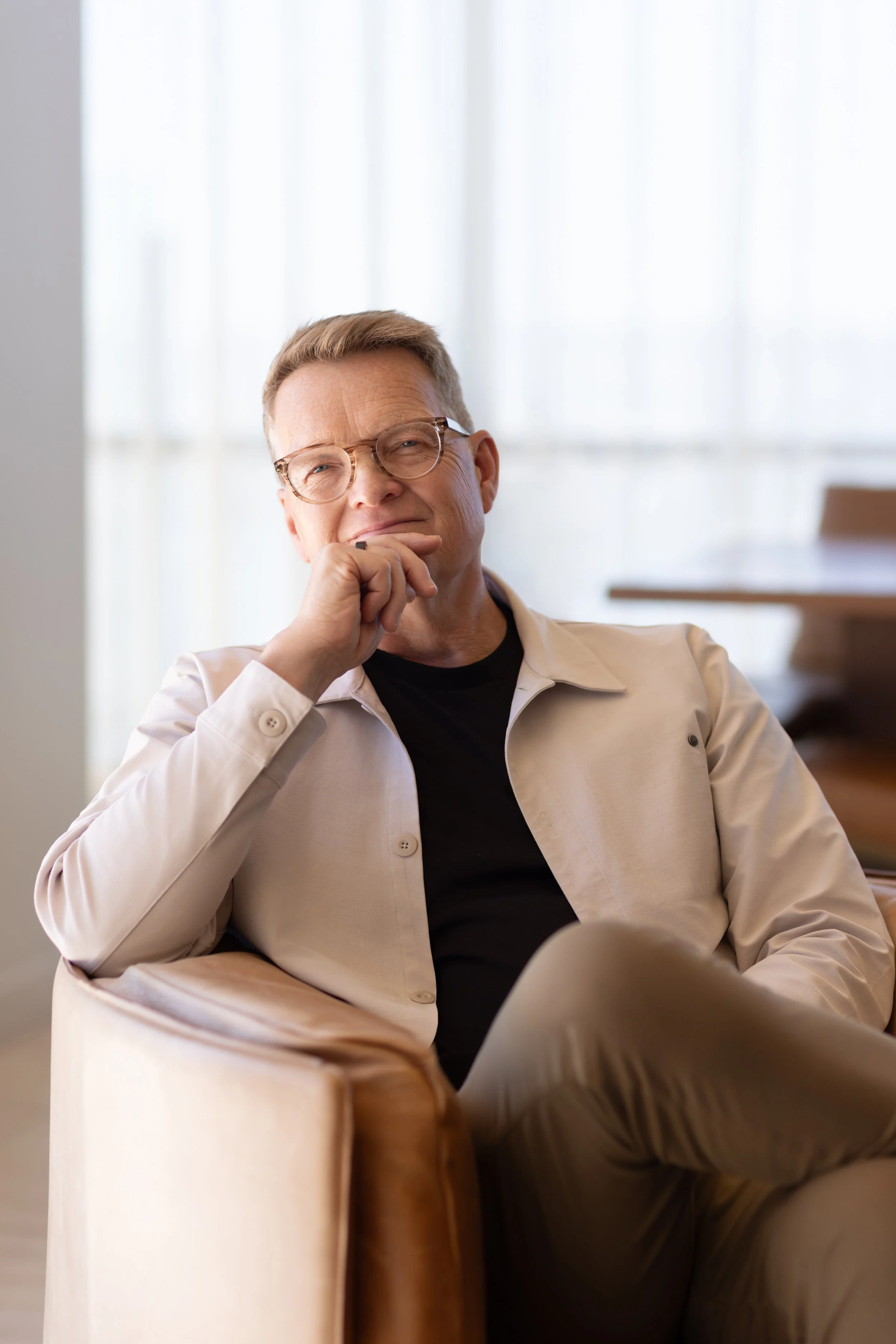 Professional man seated in a modern office environment for an on-location business portrait