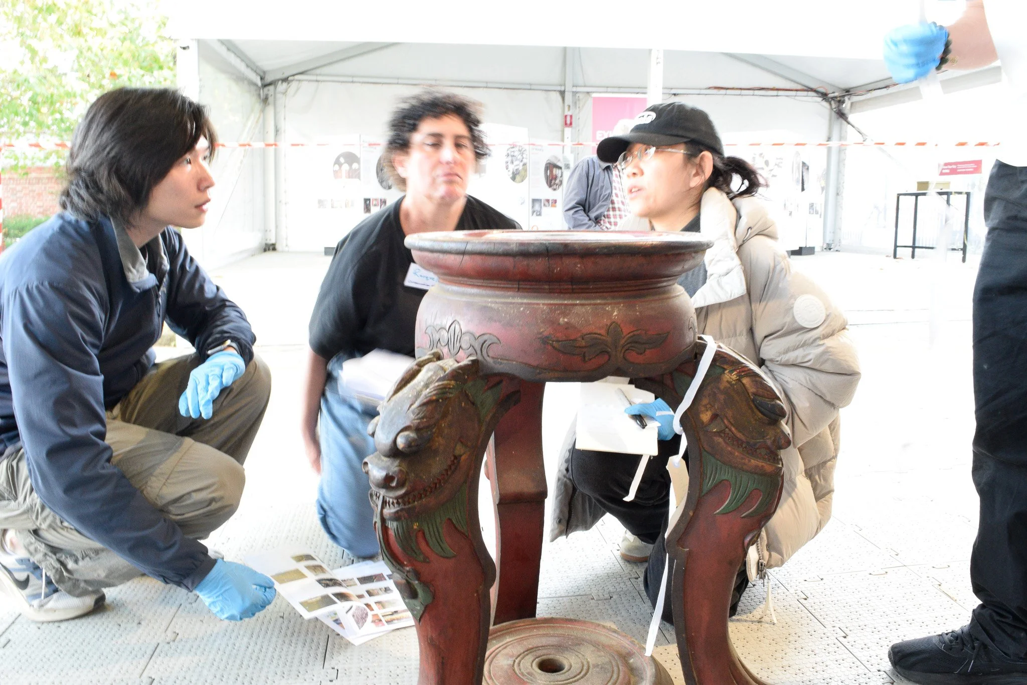  Danni Lin working with volunteers on the conservation of a temple object during the workshop. Photo: Nicole Tse 