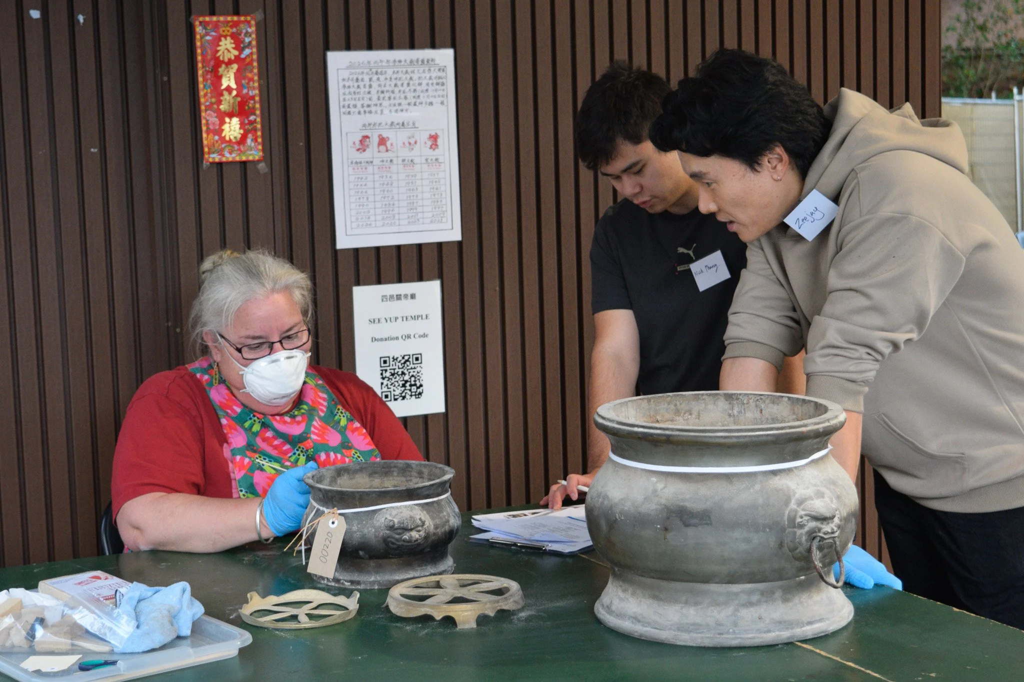  Zeejay Tan discussing&nbsp; metal temple objects with volunteers during the conservation workshop. Photo: Danni Lin 
