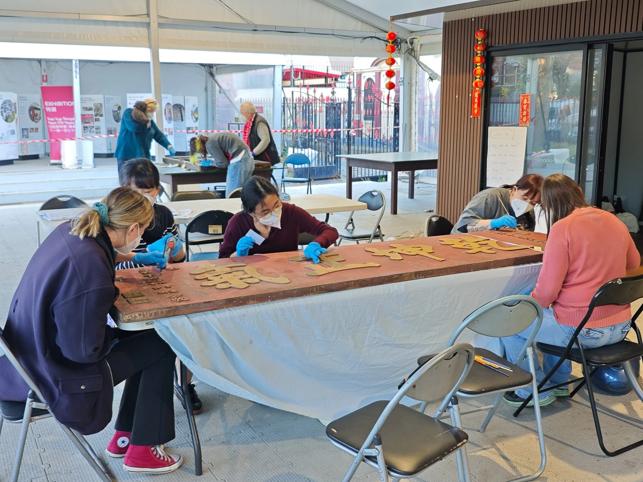  Volunteers carefully cleaning a large temple plaque during a conservation workshop at See Yup Temple. Photo：Danni Lin 