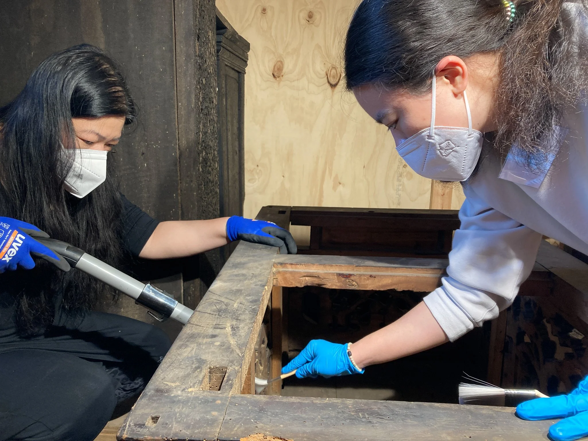  Volunteers carrying out vacuum cleaning of temple objects during a conservation workshop. Photo: Nicole Tse 