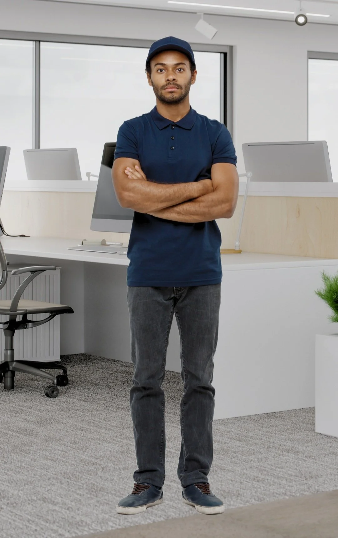 Man in a blue high quality polo knit T-shirt with logo embroidered and cap standing with arms crossed in a modern office setting - manufactured at Authent.
